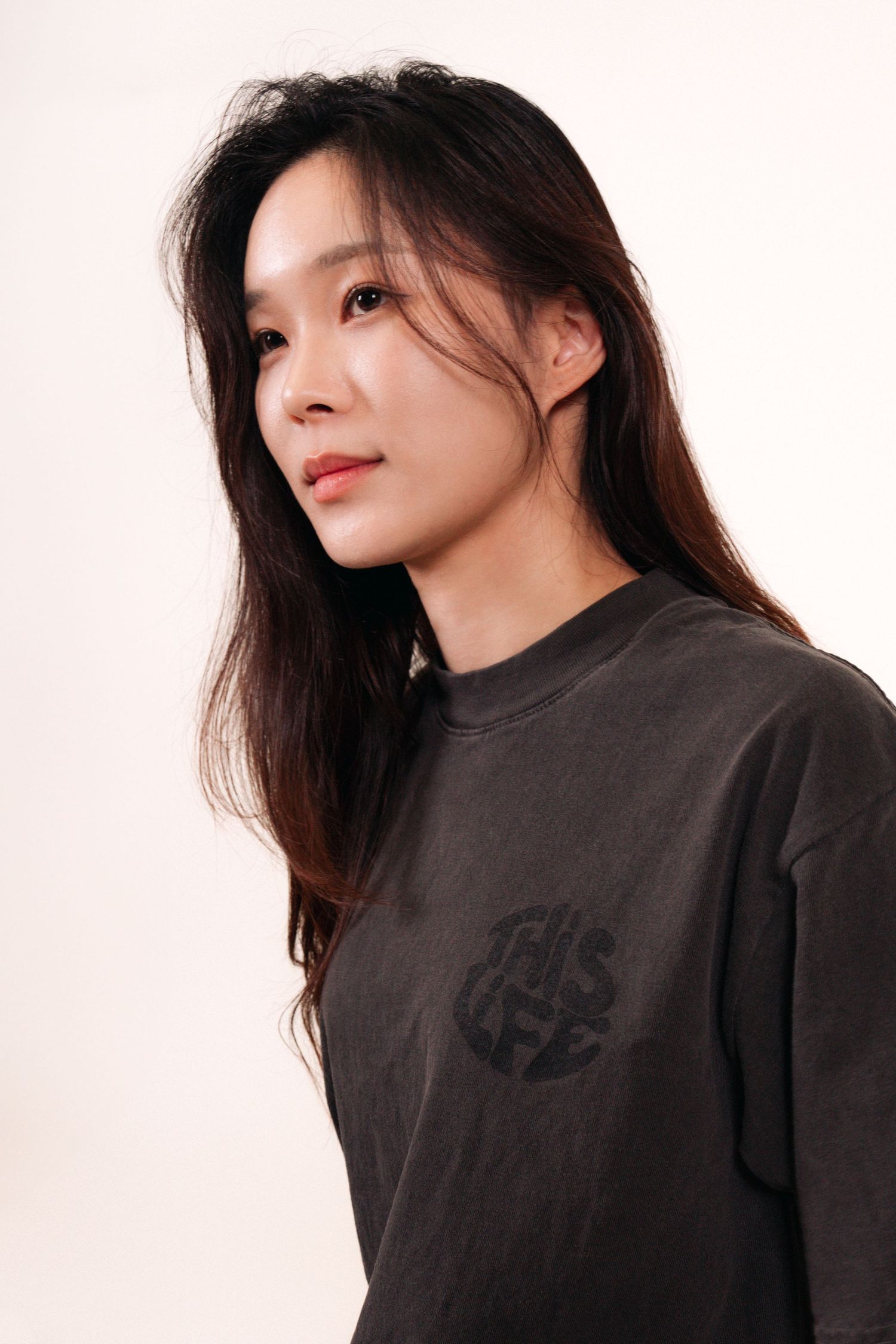 Side profile portrait of person in dark t-shirt against white background.