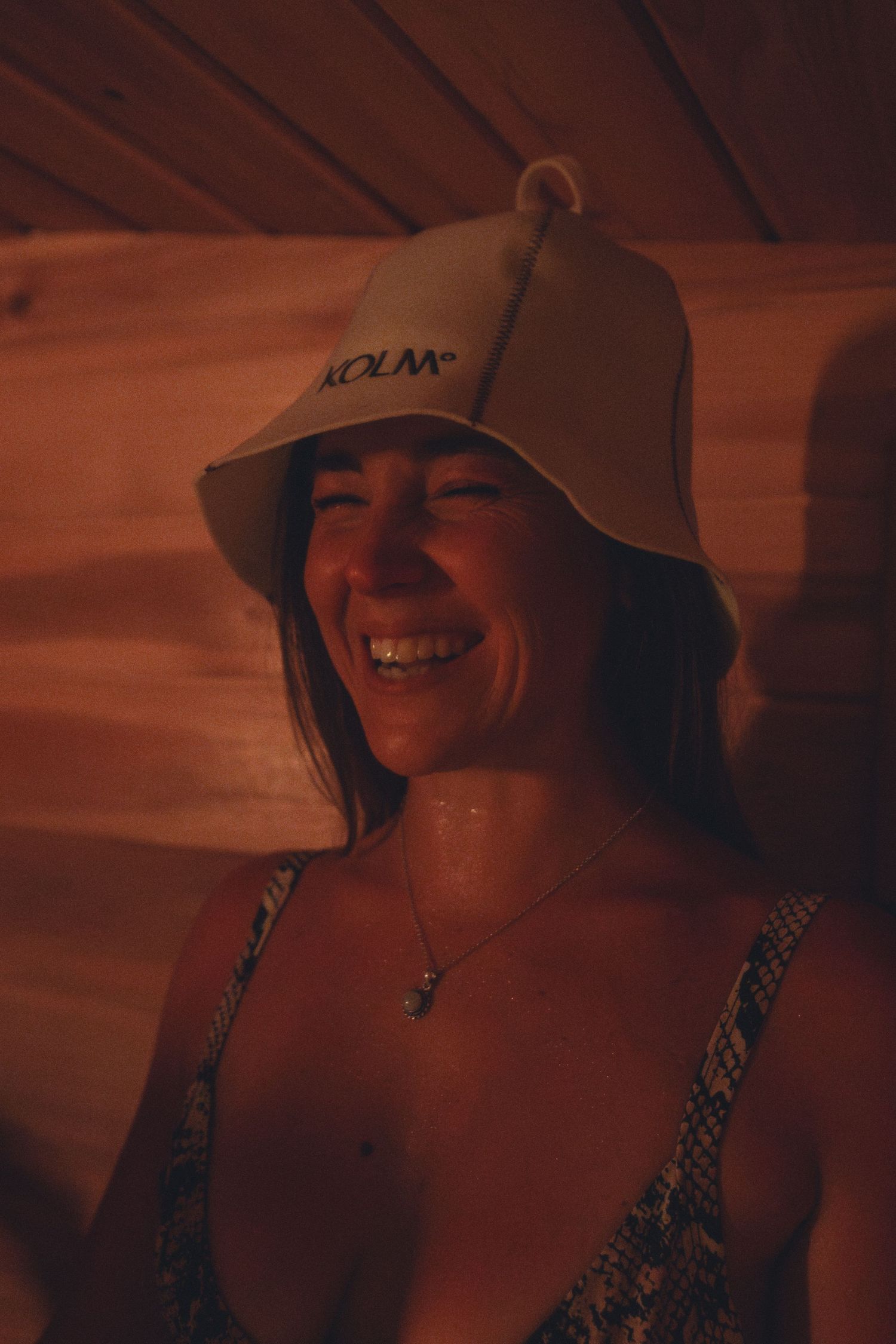 Person wearing a bucket hat smiling in warm lighting.