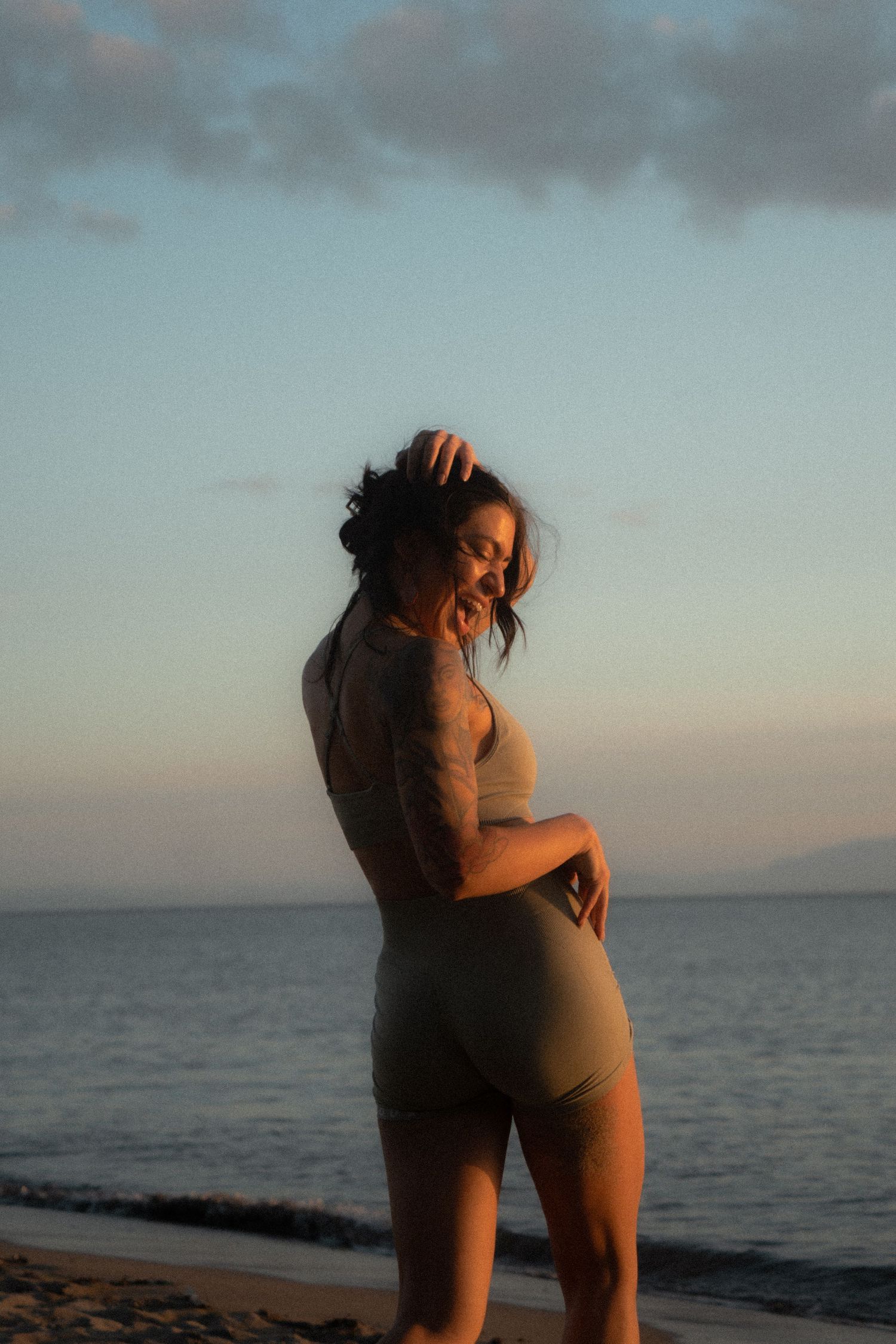 Sunset silhouette of a person posing against an ocean backdrop.