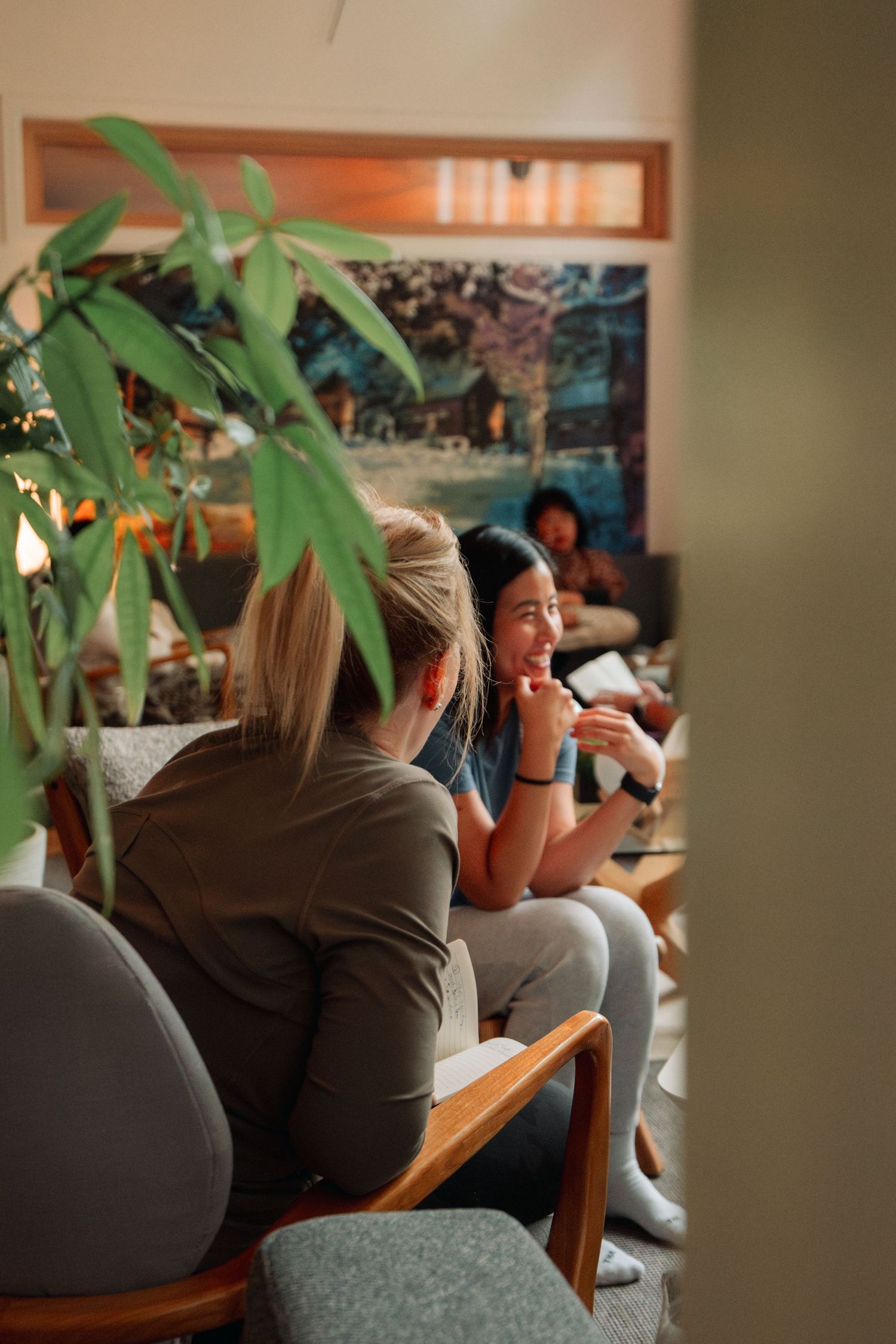 Indoor social gathering space with houseplants and mid-century modern furniture.