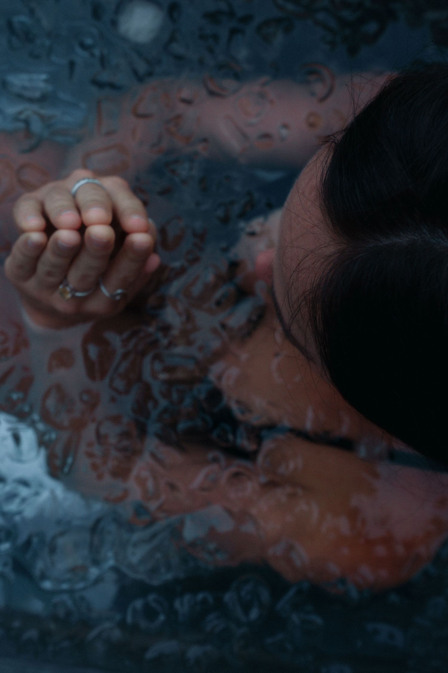 Artistic overhead view of water droplets with moody blue lighting.