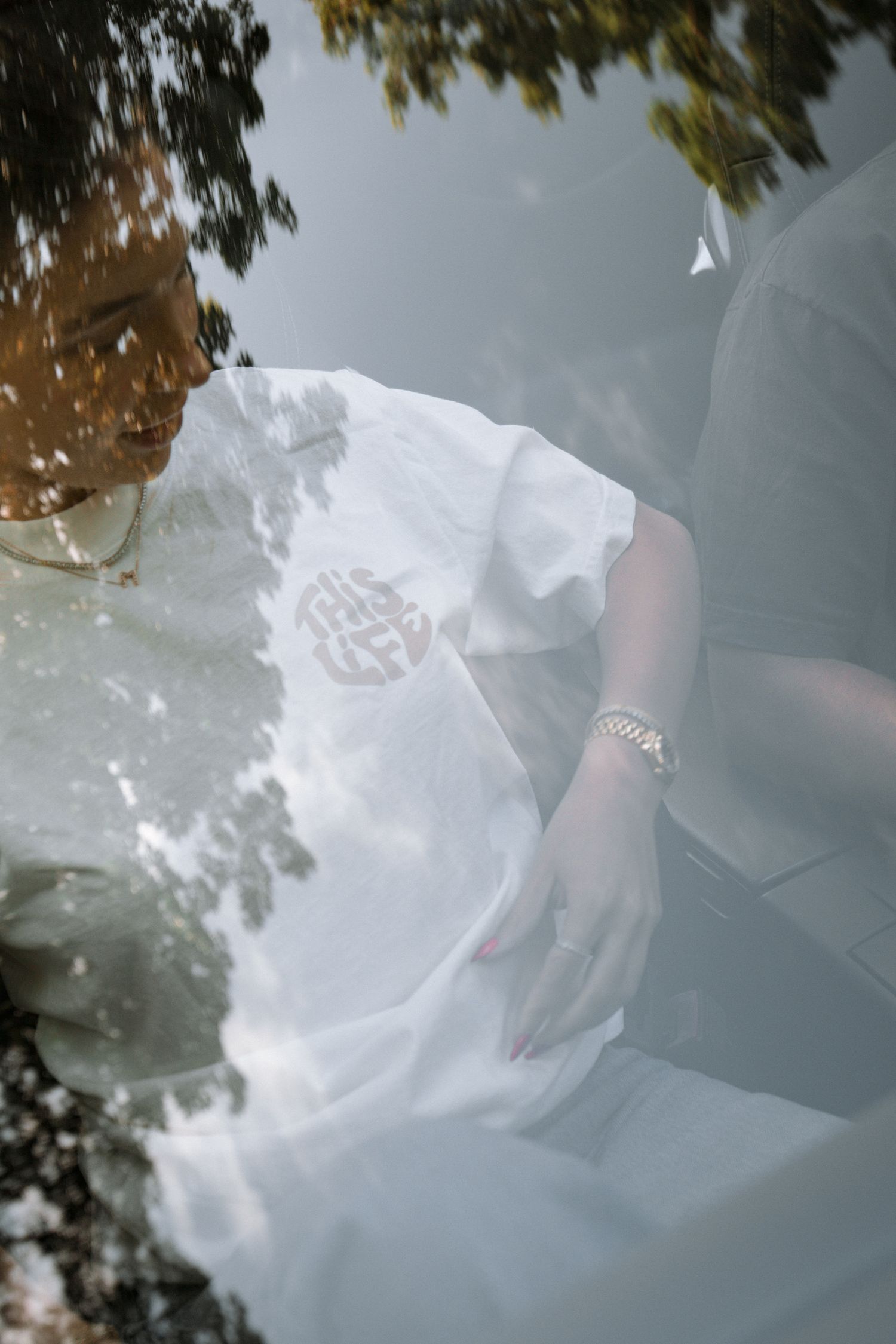 Artistic close-up of a white t-shirt with reflections in glass.