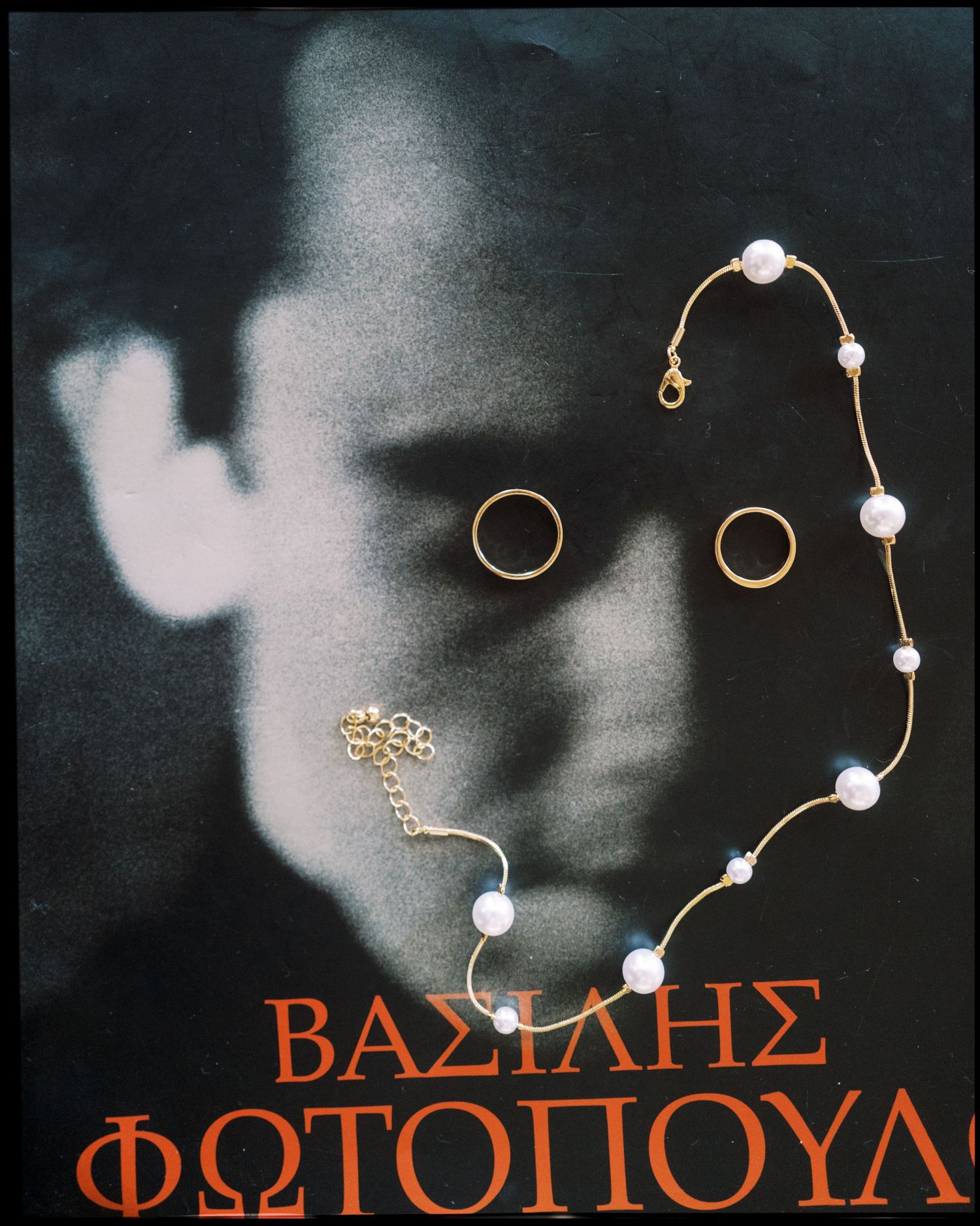 Abstract black and white art piece with gold jewelry and white pearl accents creating an ethereal composition.
