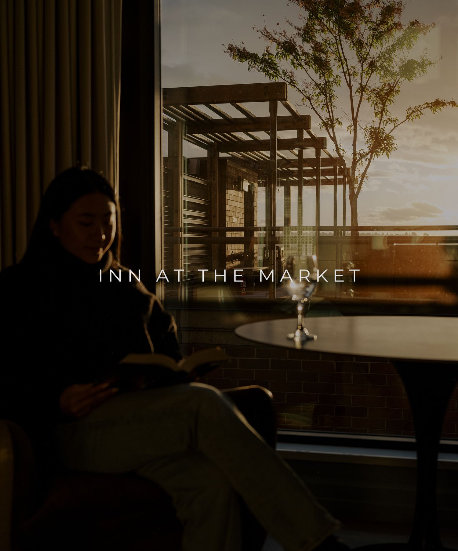 A relaxing patio scene at sunset with a pergola and person silhouetted against warm evening light.