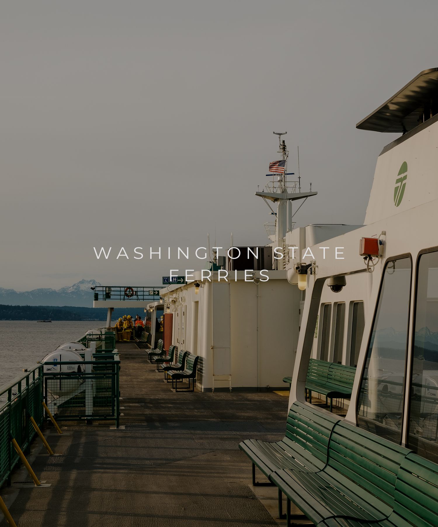 Deck view of a Washington State Ferry with passenger seating and navigation equipment visible against a cloudy sky.