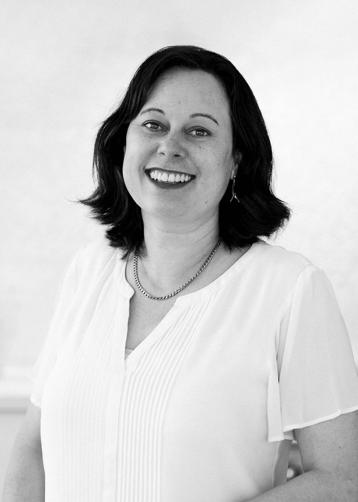 Professional headshot. Real Estate Agent, clean Black & white image of woman smiling and relaxed for a professional headshot CL Photography