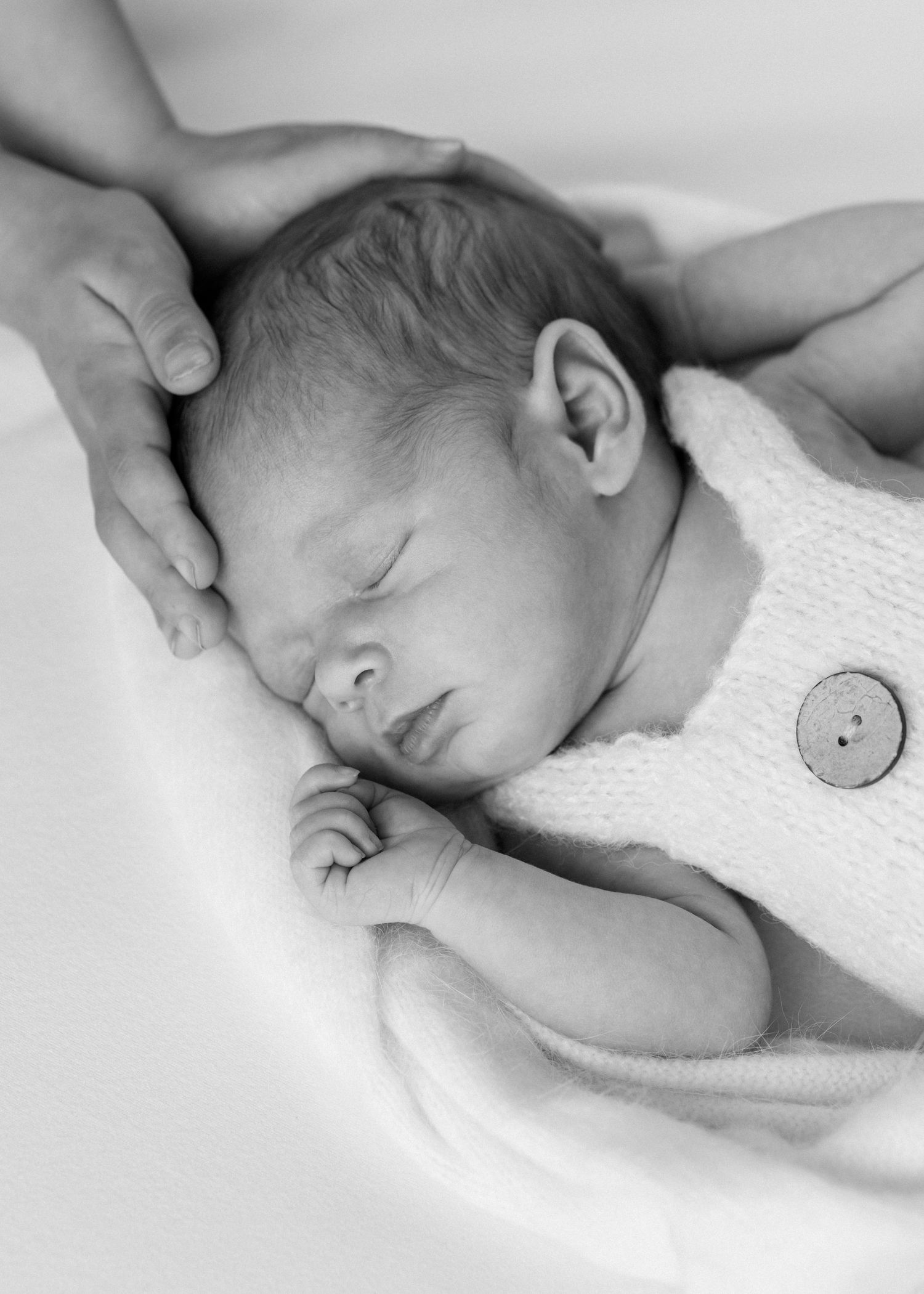 two little hands cradle baby's header a newborn photoshoot in Auckland by Catherine Lundin Photography. Newborn photography. Simple and soft