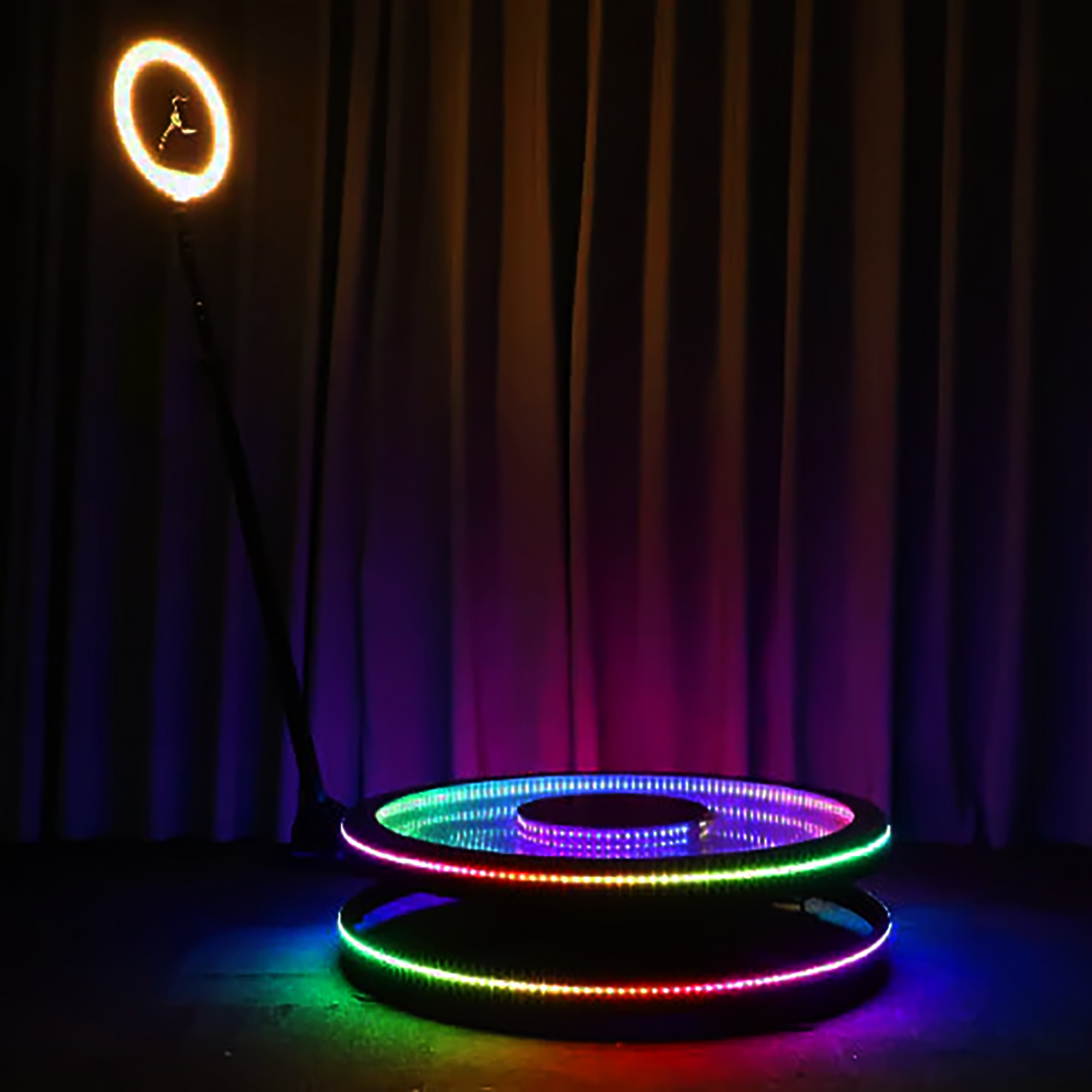 Circular LED platform with colorful RGB lighting effects against black background.