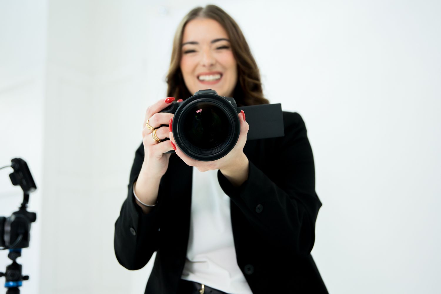 Photographer demonstrating camera equipment in bright studio environment.