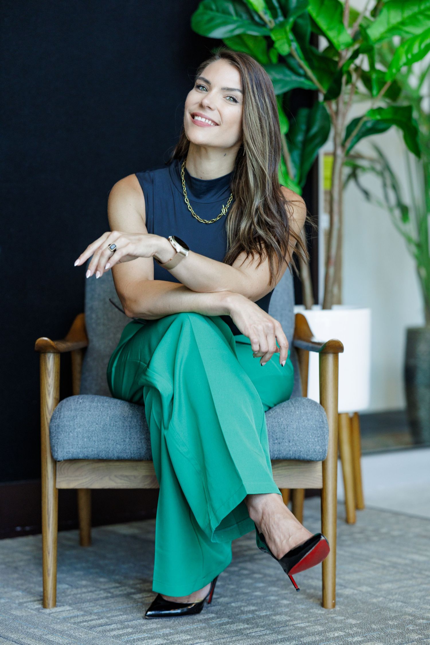 Stylish portrait session with emerald green pants and navy top in modern setting.