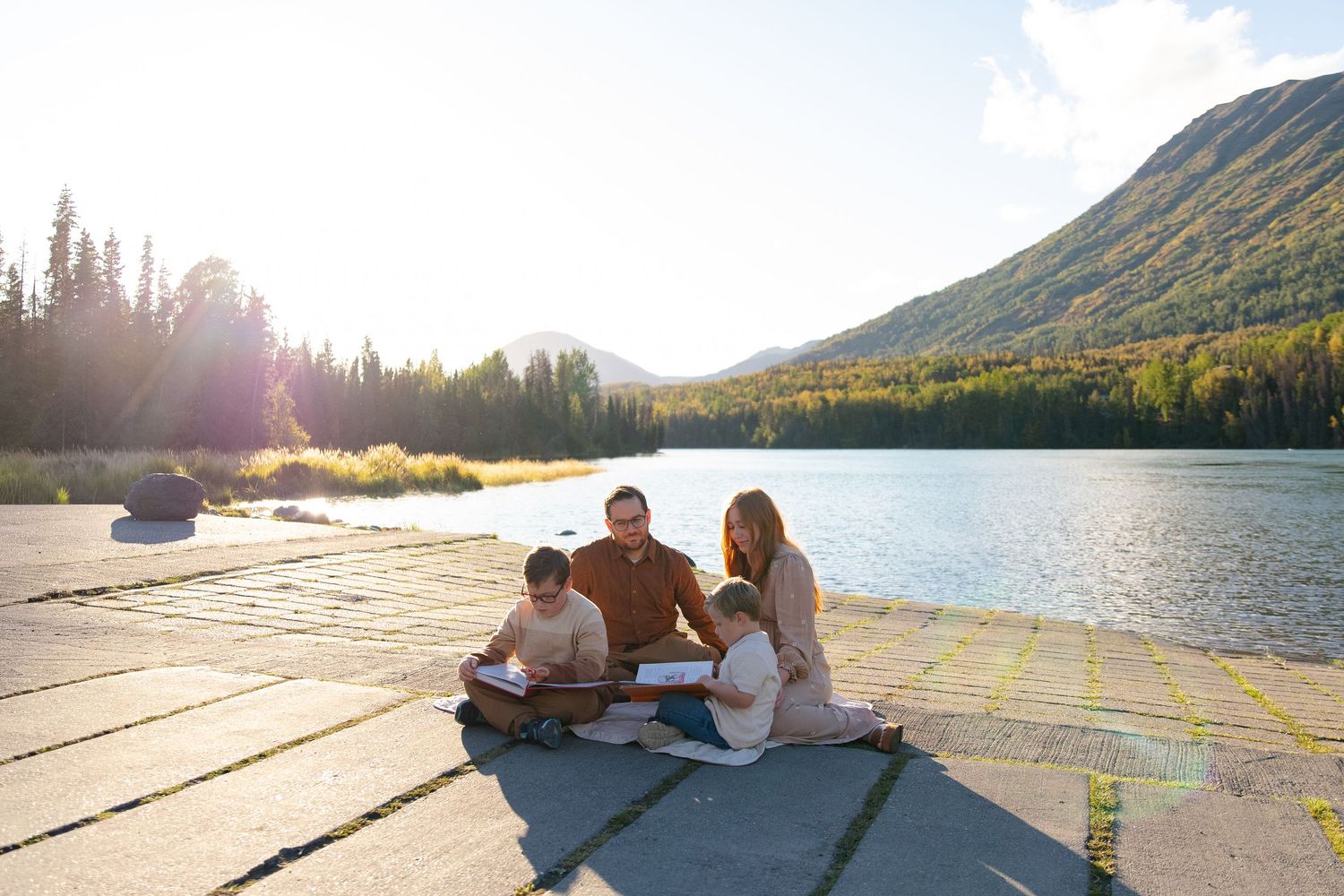 Panoramic sequence of a family enjoying time together by a mountain lake at sunset, in Cooper Landing, Alaska.