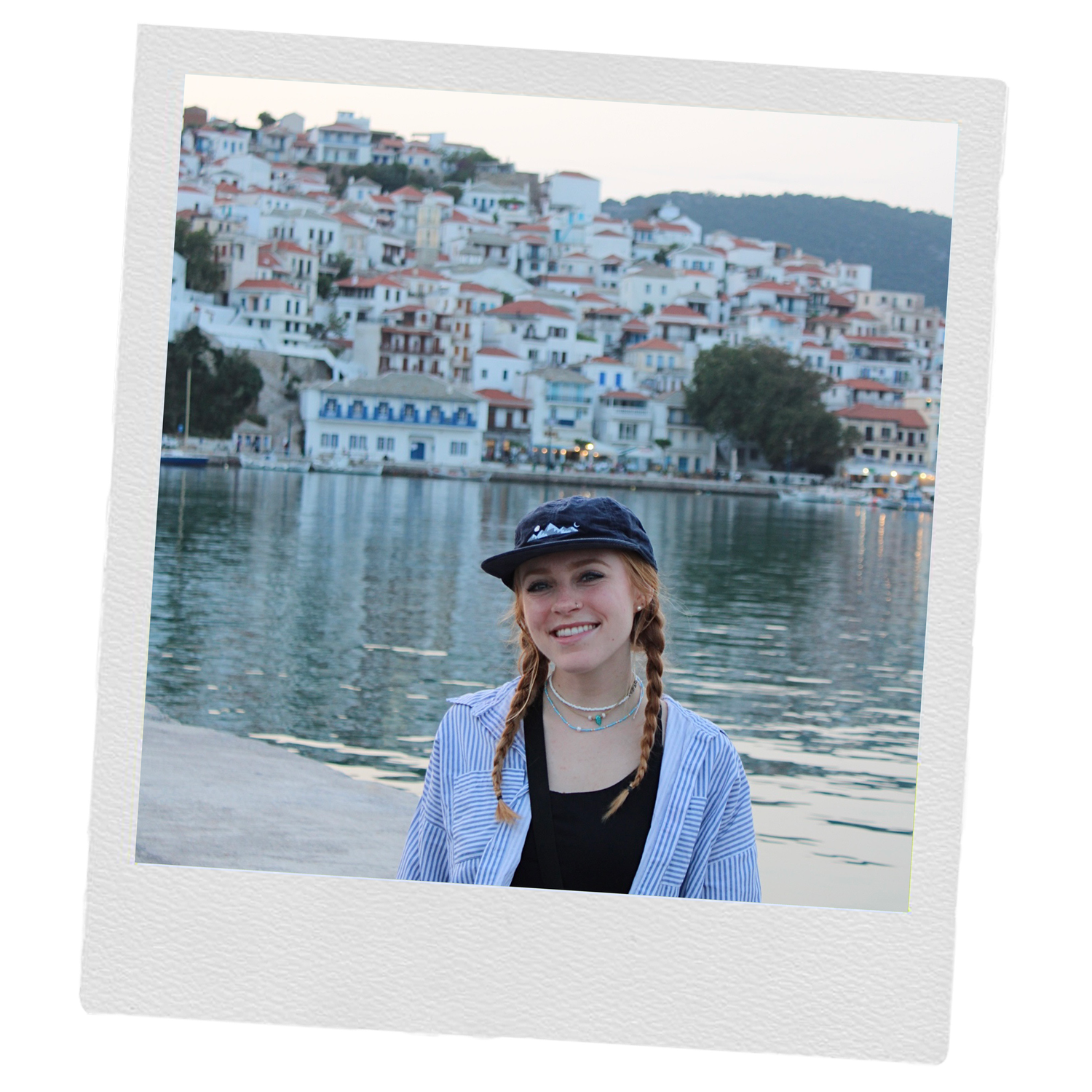 Scenic waterfront view of white Mediterranean buildings along a blue harbor.