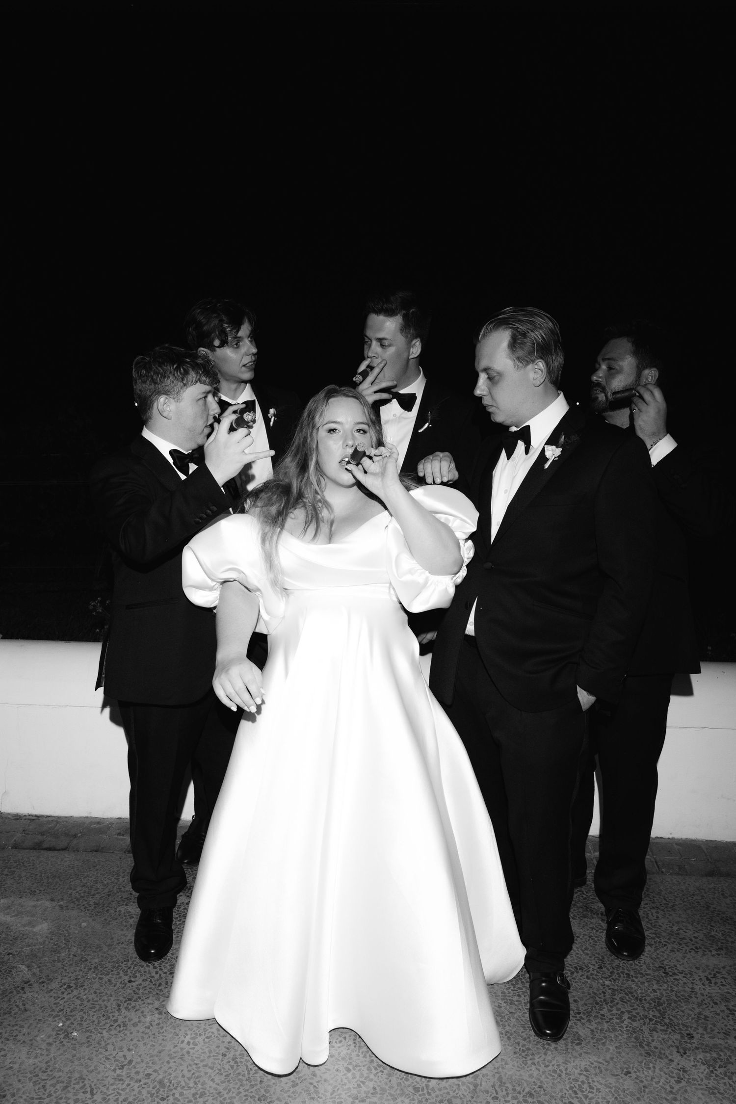 Young children in formal attire dance and play together at an elegant black and white event.
