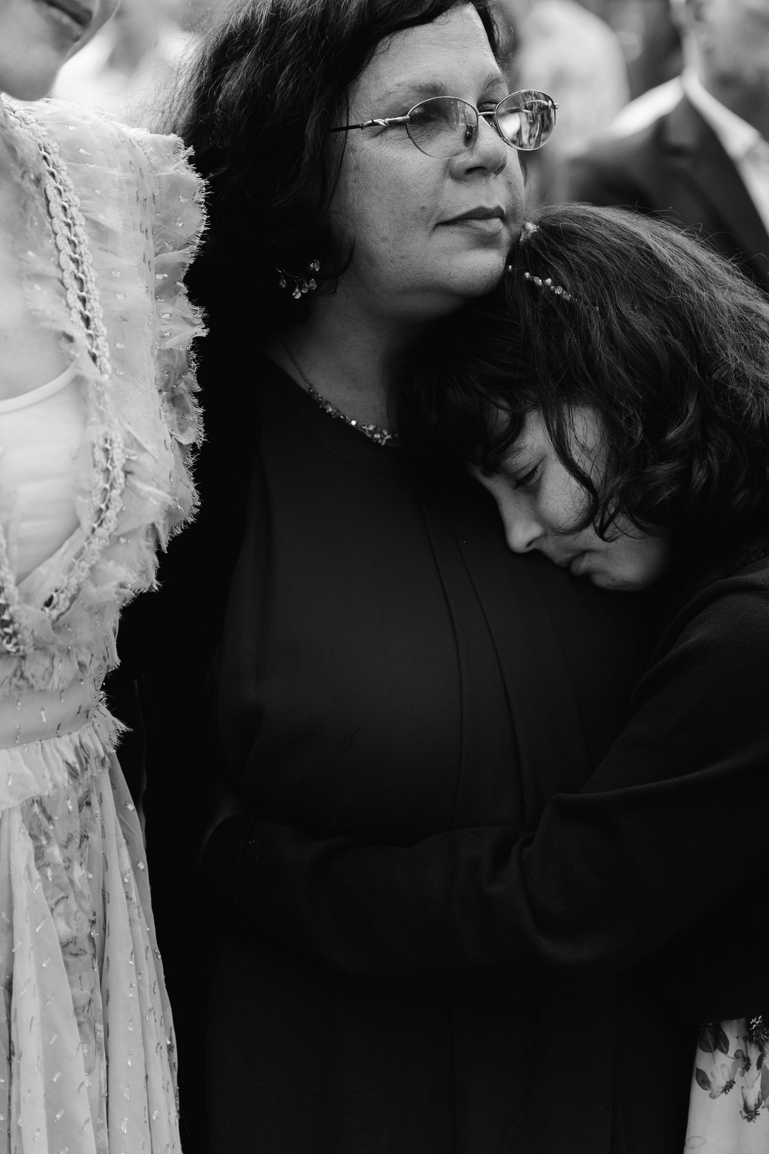 A black and white photograph shows two people embracing in a tender moment, with white decorative elements visible.