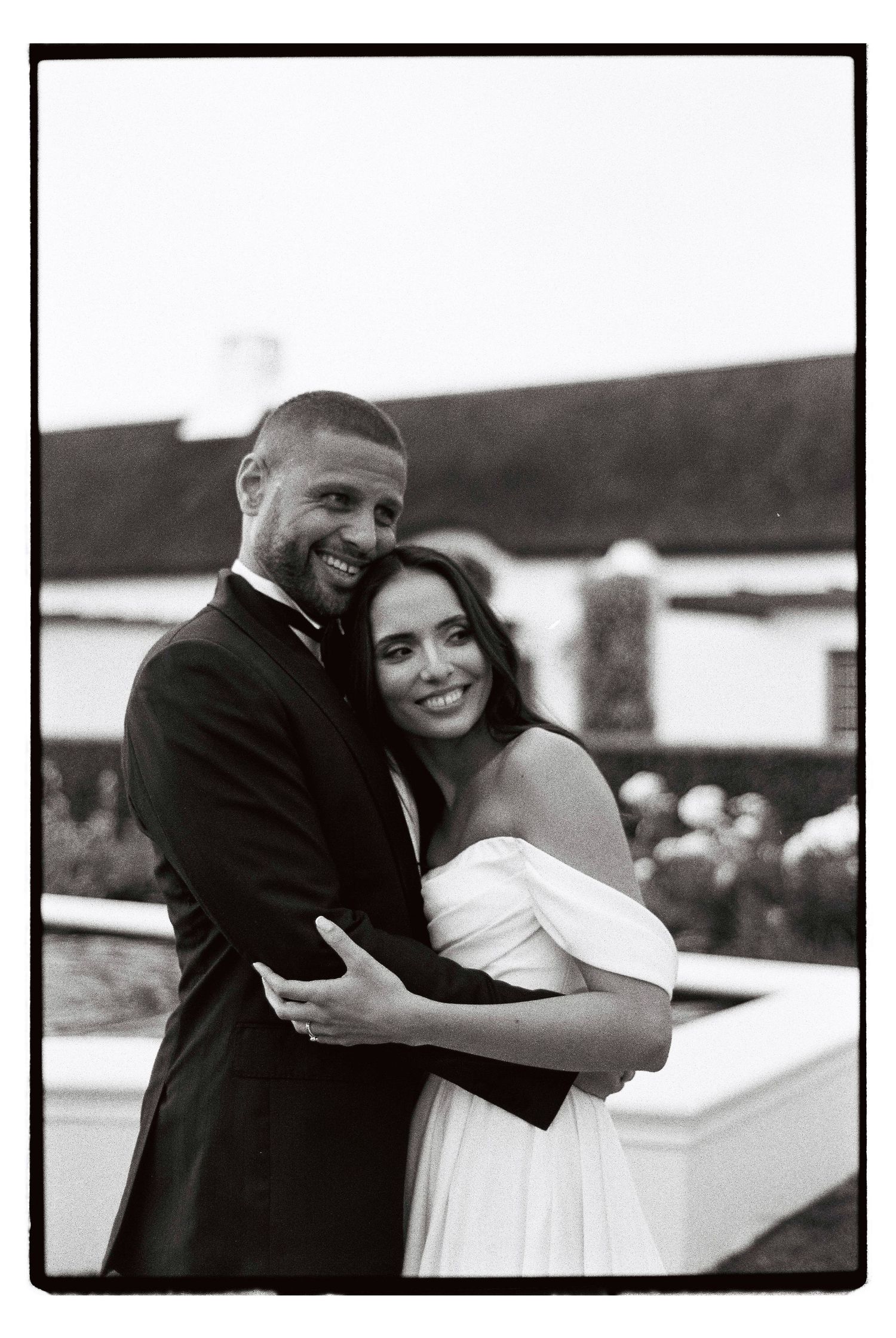 A joyful moment captured in black and white at an outdoor wedding celebration.