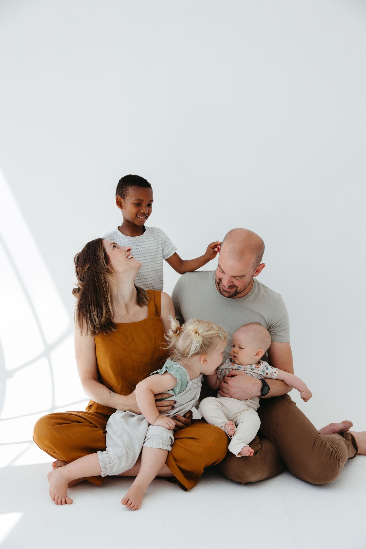 Loving family sharing a playful moment together on white background.