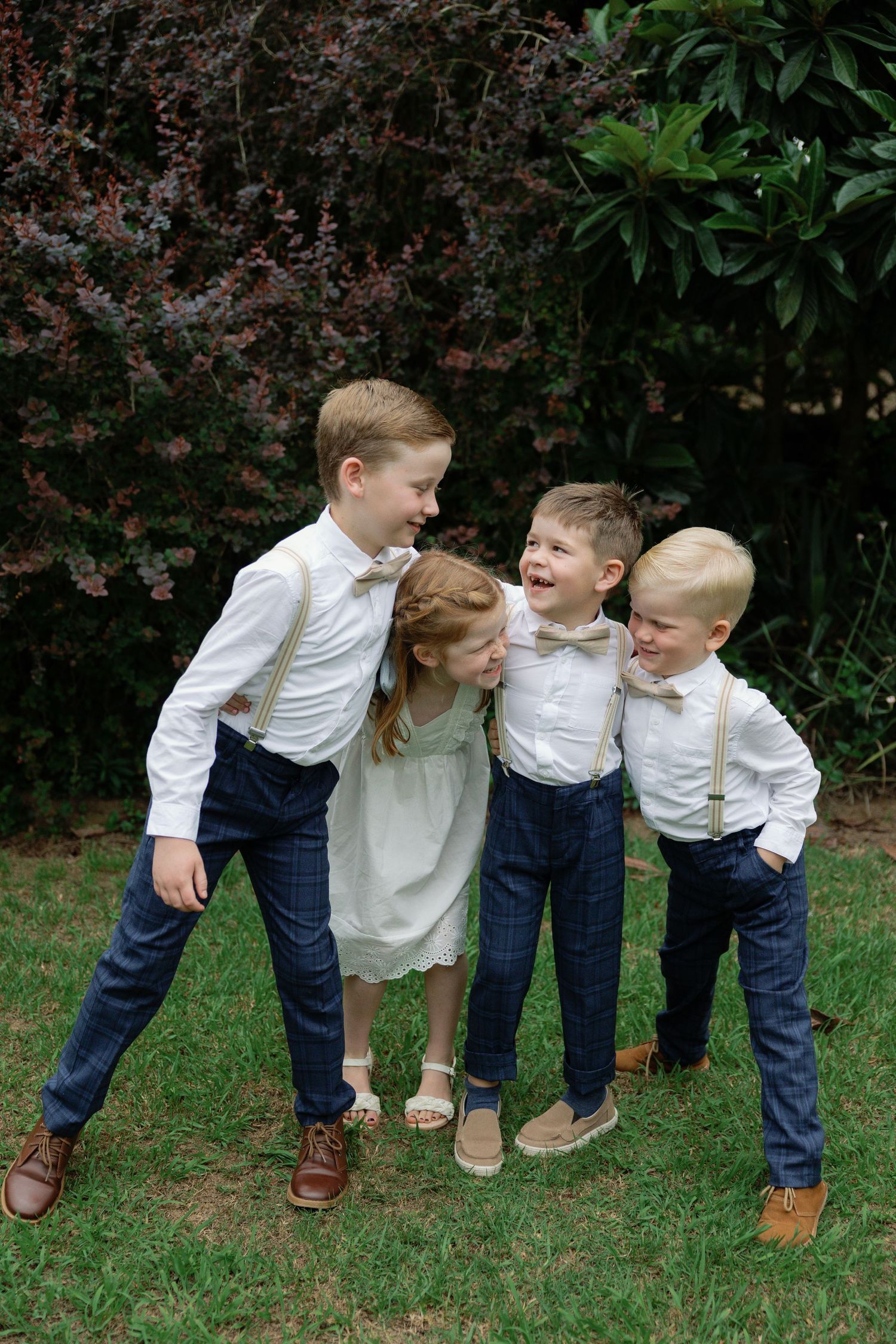 Playful group wearing matching white shirts and jeans posing together outdoors.