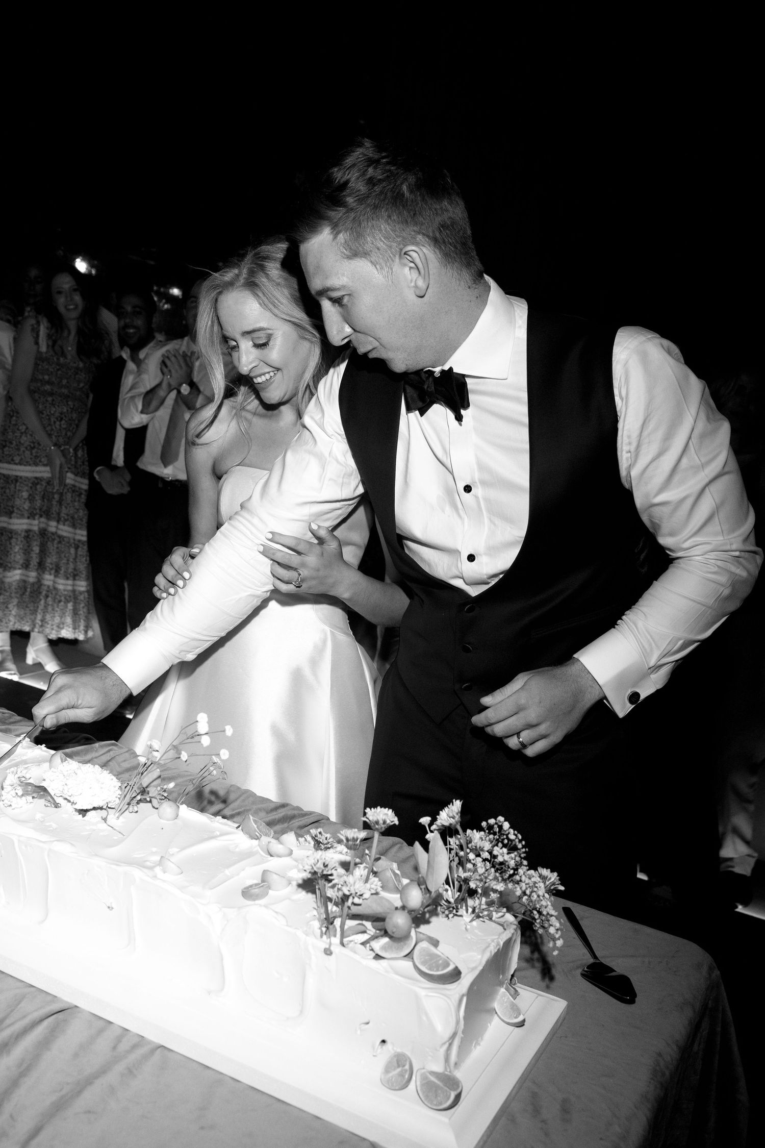 A black and white photo sequence shows someone decorating cupcakes with frosting at a formal event.