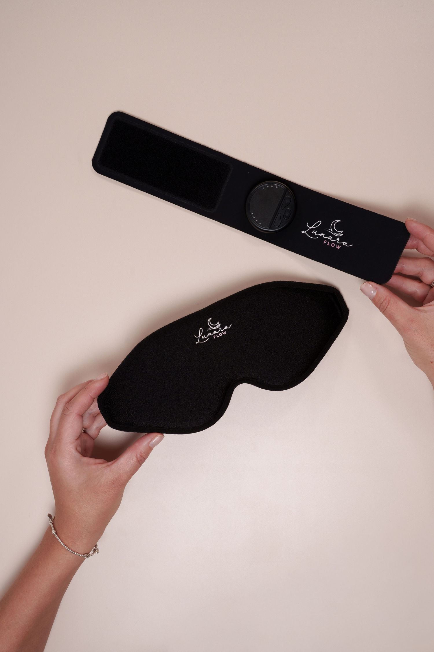 Hands holding a black weighted sleep mask and its case with Luna branding on a beige background.