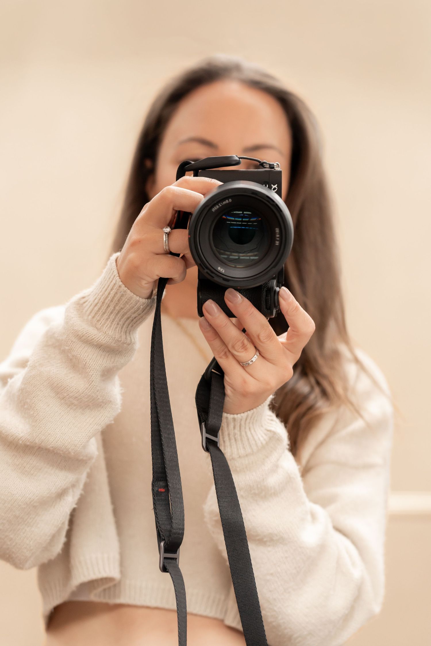 Person in cream sweater holds black camera while taking photos in sequence showing different angles and positions.