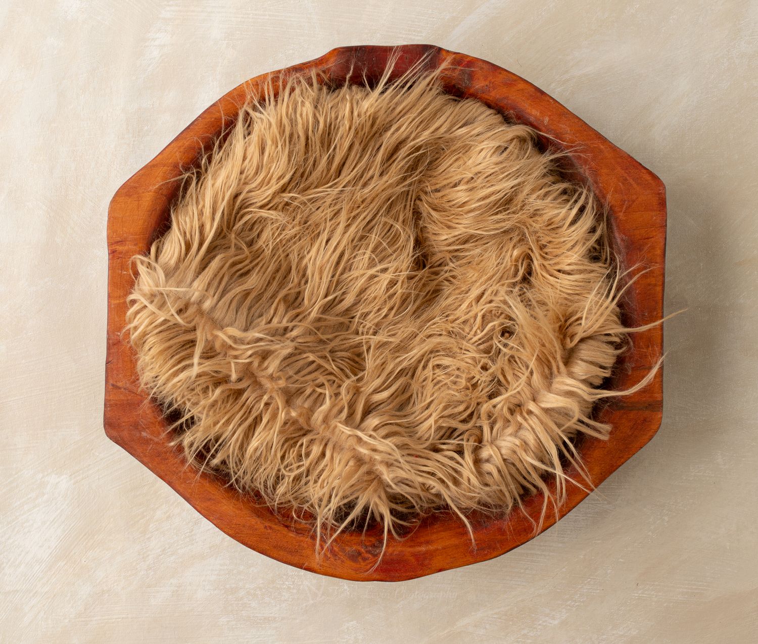 Octagonal wooden bowl filled with soft, fluffy tan faux fur, perfect for newborn photography props.