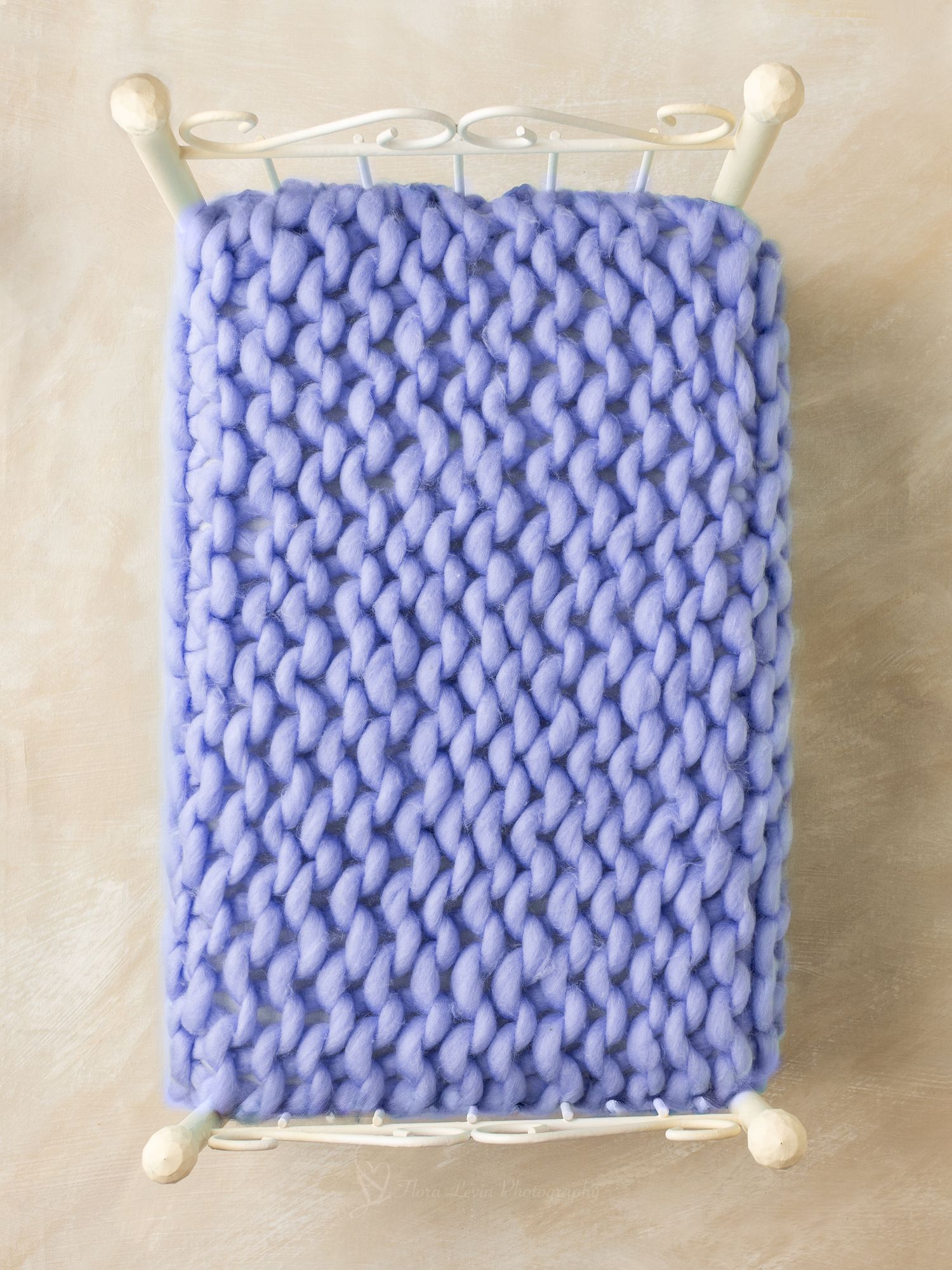White metal prop bed with chunky knit purple blanket, perfect for newborn photography props.