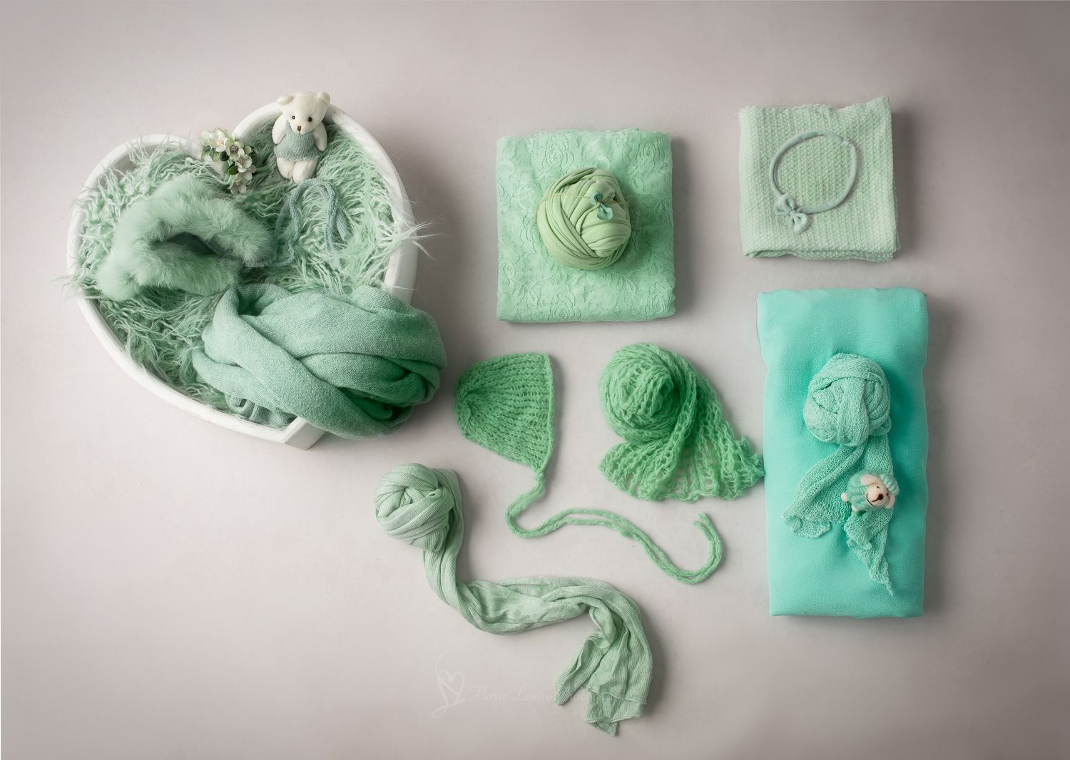Mint green newborn photography prop set including wraps, bonnet, headband, and accessories arranged on white background.