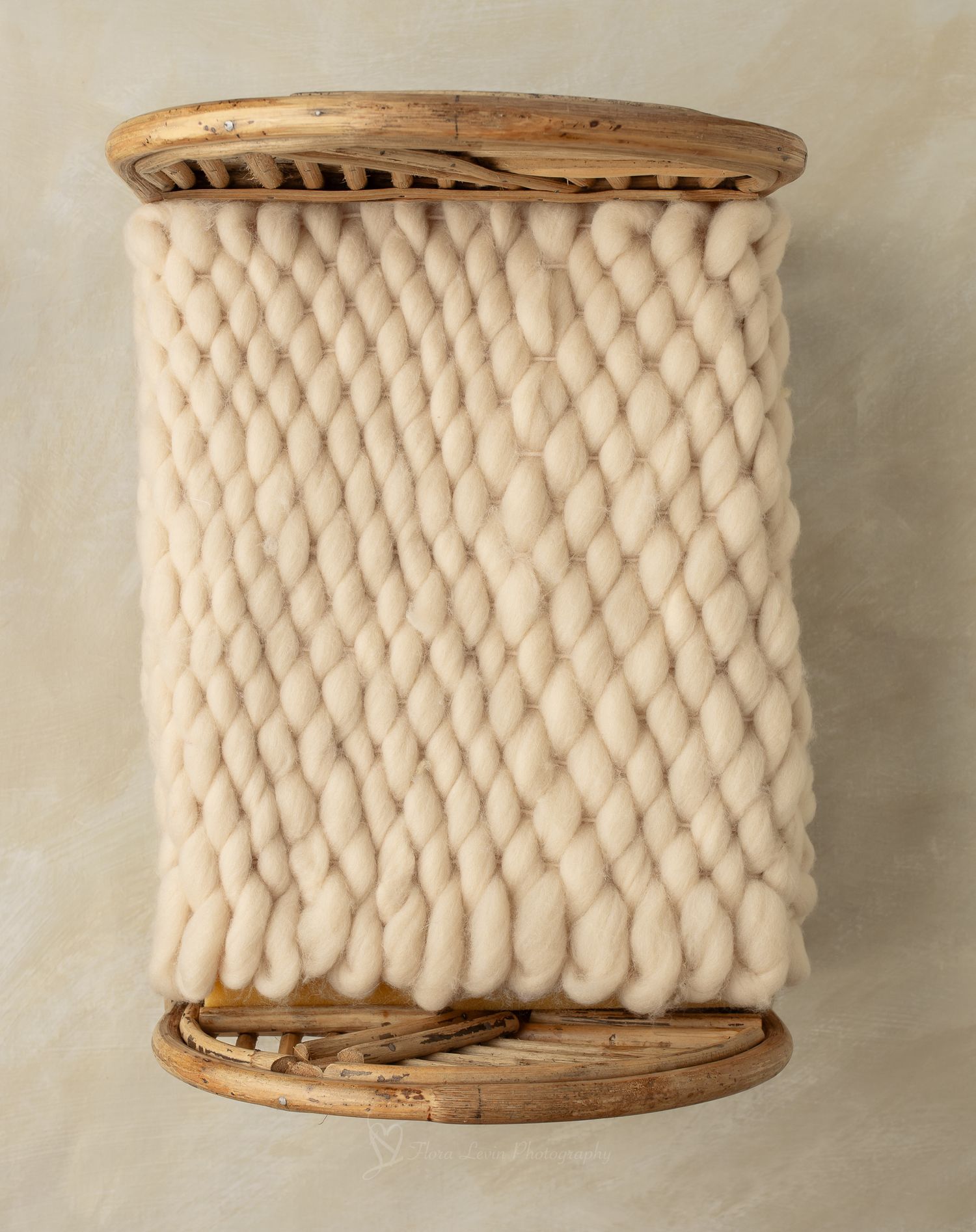 Rustic bed with chunky knit wool blanket, perfect for newborn photography props.