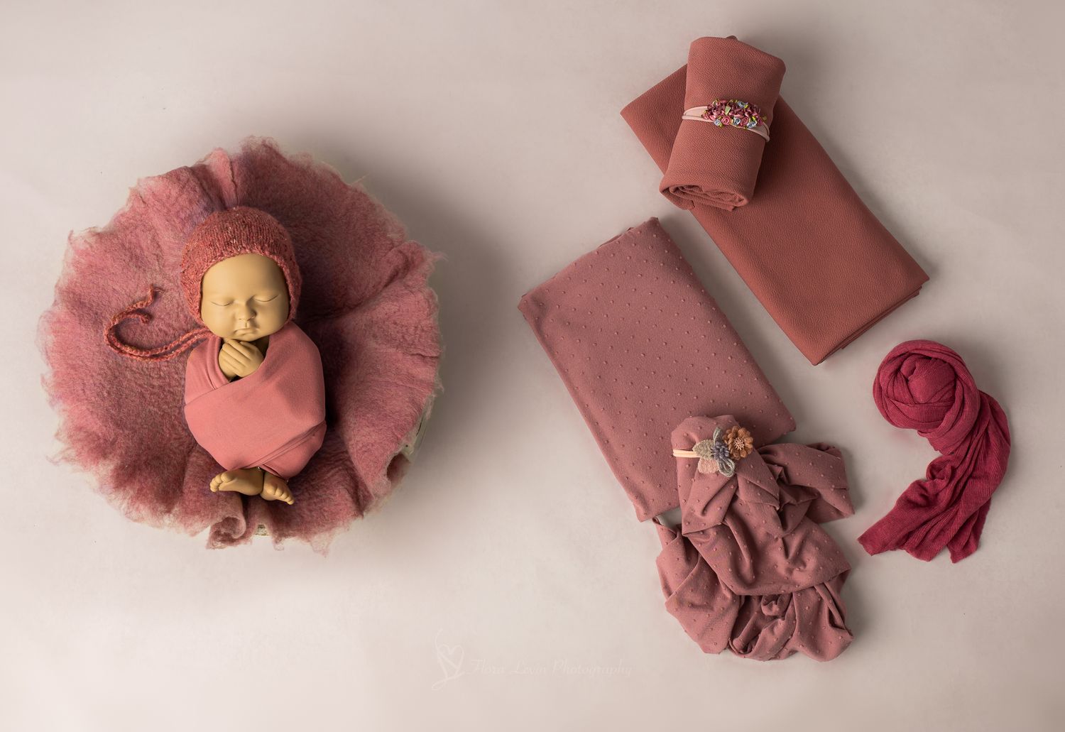 Pink newborn photography props set with baby posed in mauve wrap, fabric layers, headbands, and  wrap accessories.