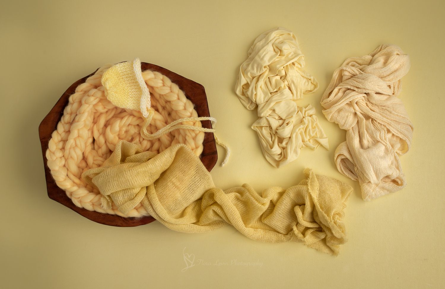 Soft pastel fabric wraps and layers  yellow tones arranged on a yellow background.