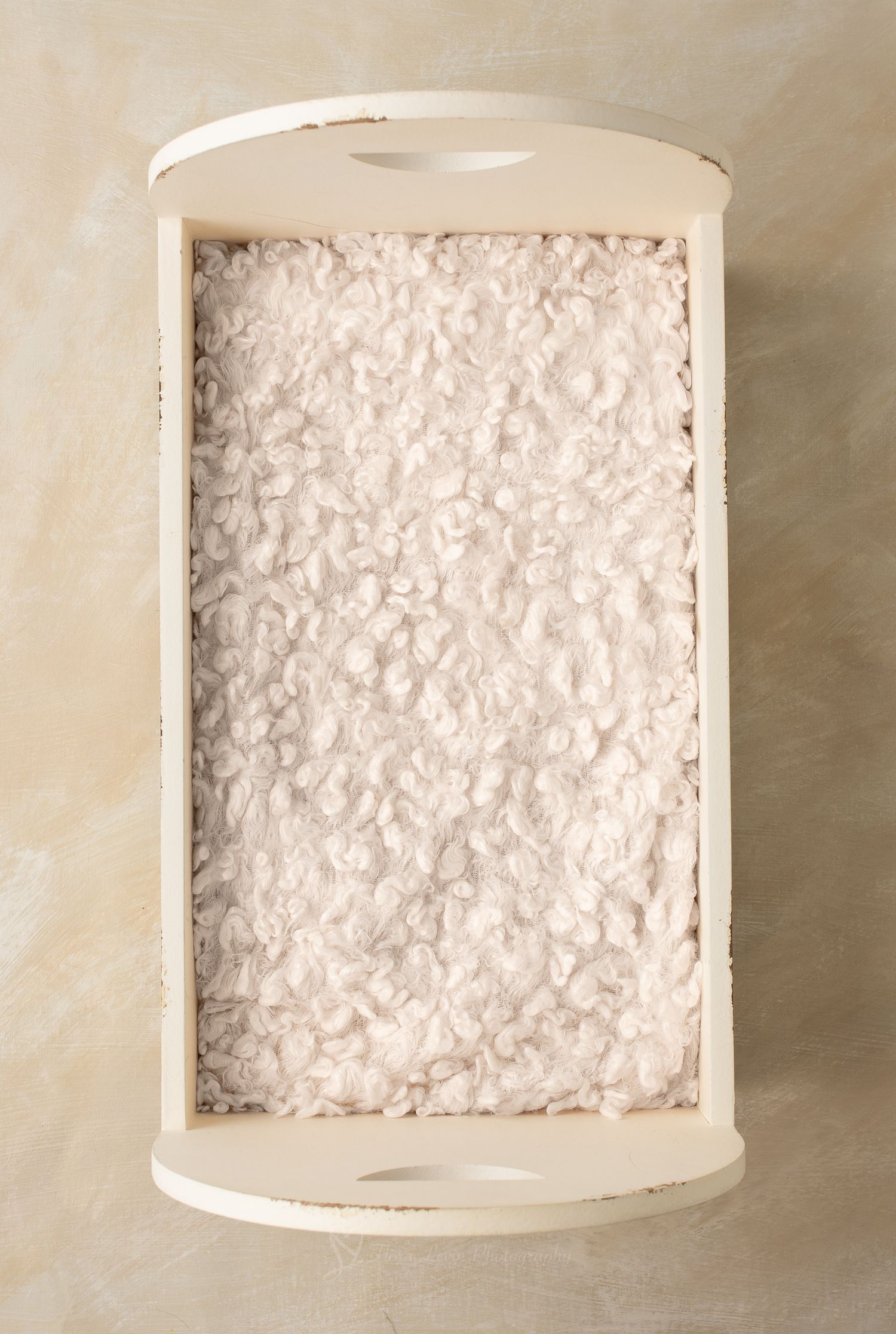 Vintage white wooden  bed with heart cutouts and fluffy lace mattress on beige background.