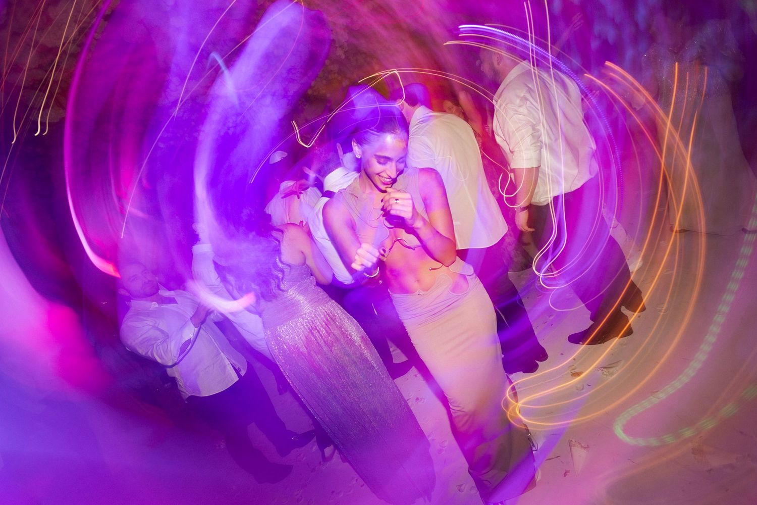 Abstract purple and gold swirling light trails create a mesmerizing pattern in long exposure photography.