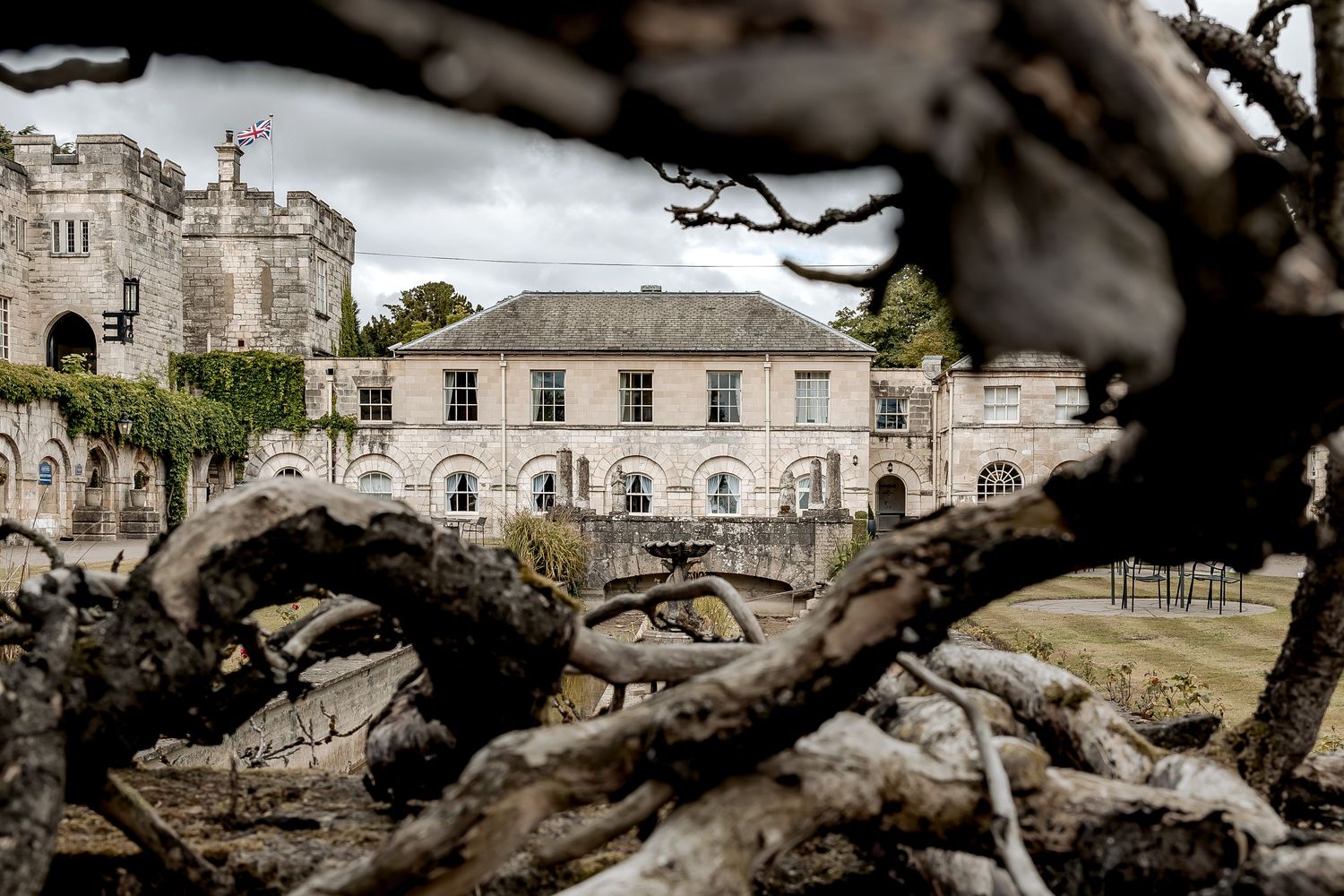 Historic stone building ruins with ancient arched windows and doorways set against a cloudy sky.