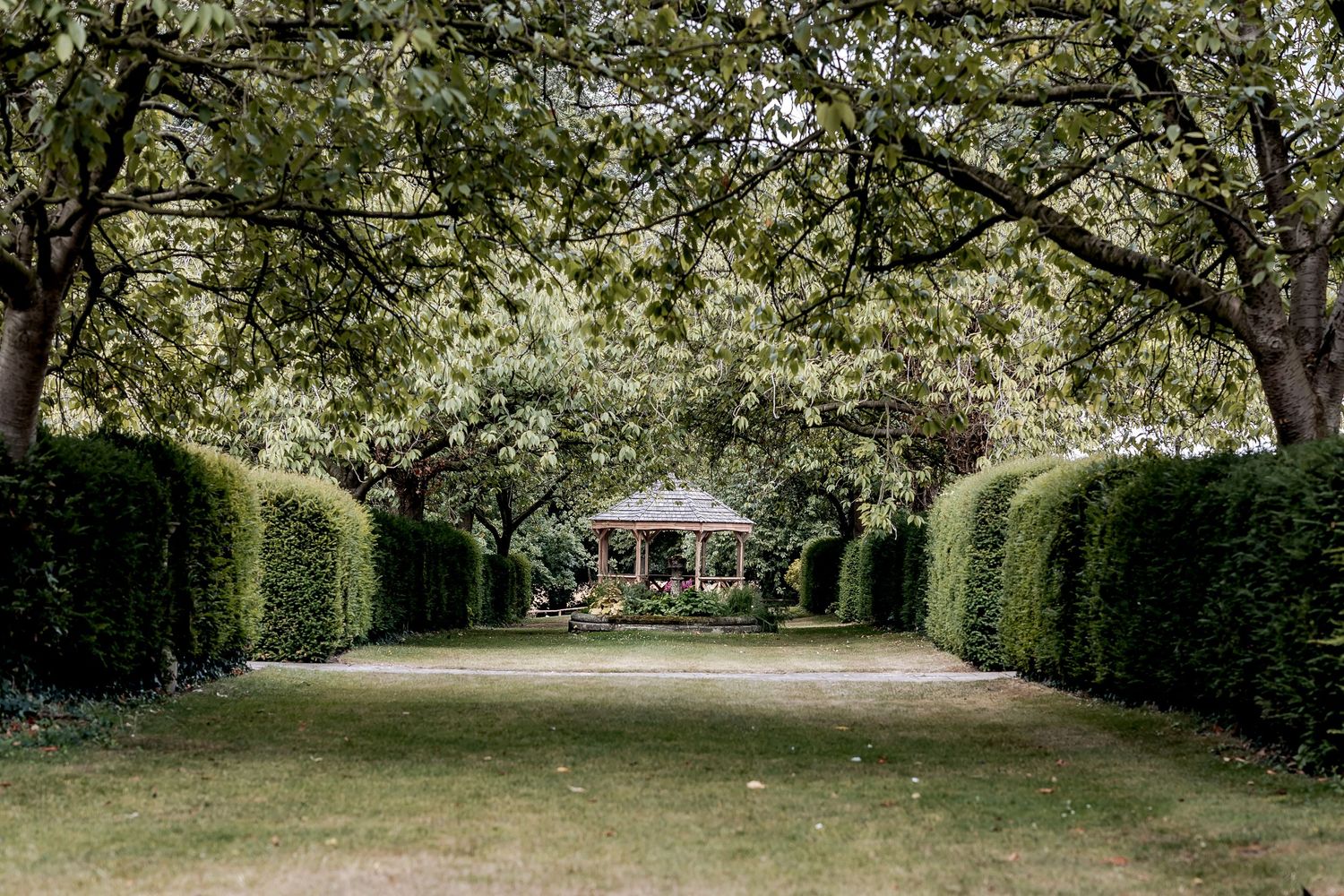 A series of outdoor garden views showing lush greenery, pathways, and landscape elements in a peaceful venue setting.