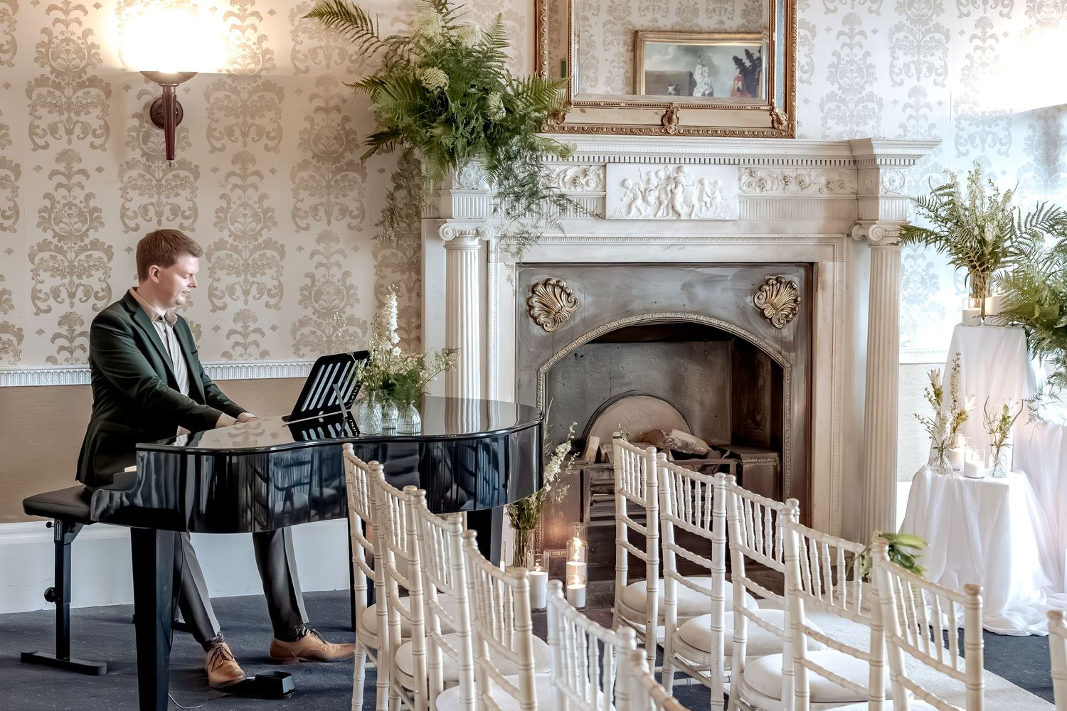 Interior view of an elegant wedding venue with white chairs, floral arrangements, and rustic stone wall details.