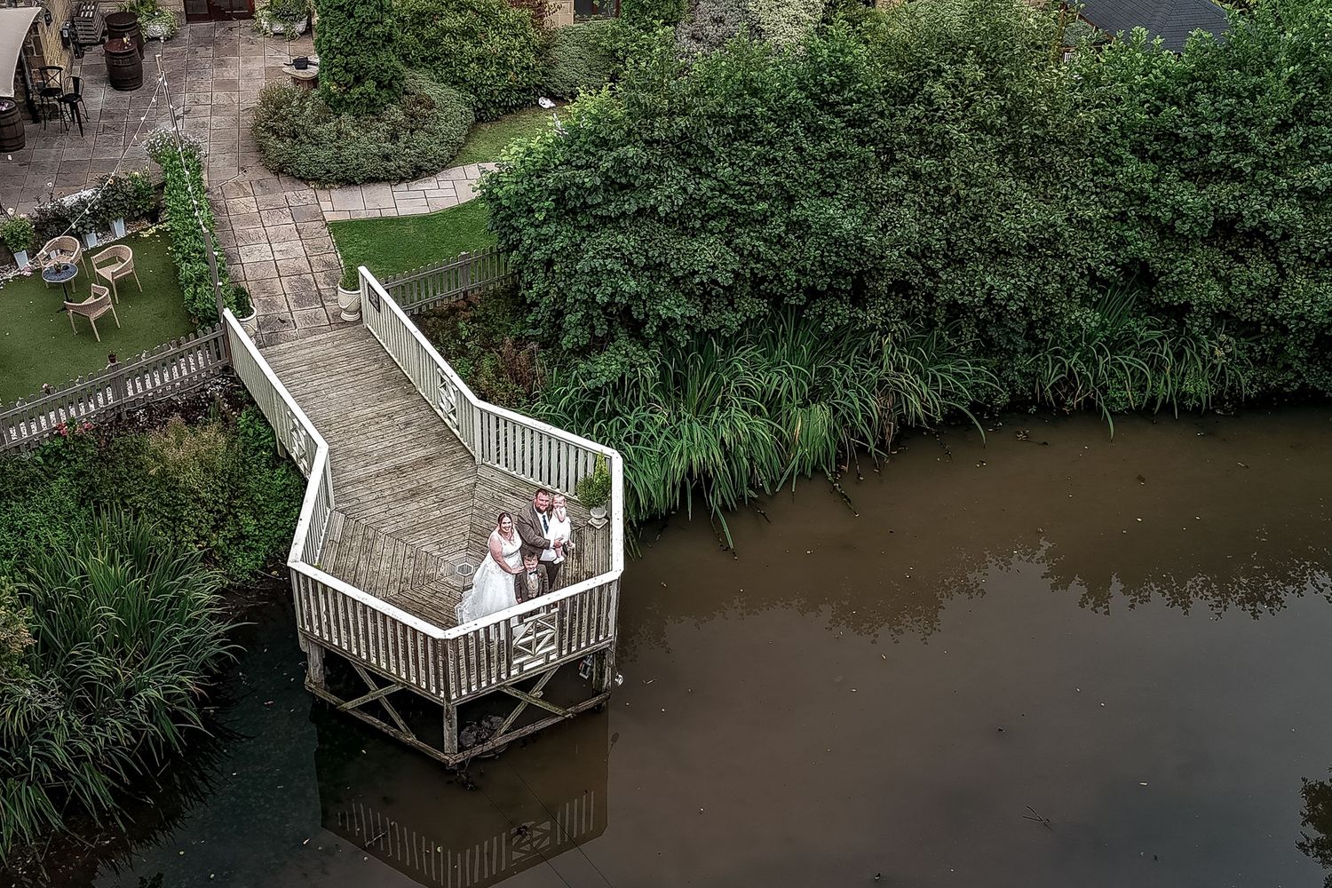 Aerial view of a wooden boardwalk winding through lush green wetlands with multiple viewing platforms.