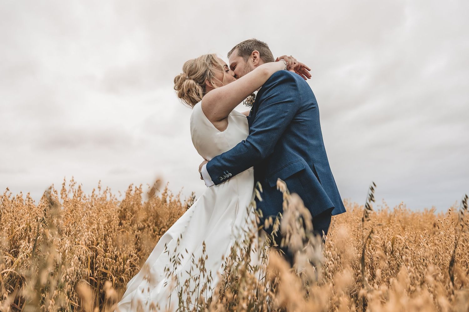 A romantic wedding moment during a wedding day captured in a field by a documentary photographer