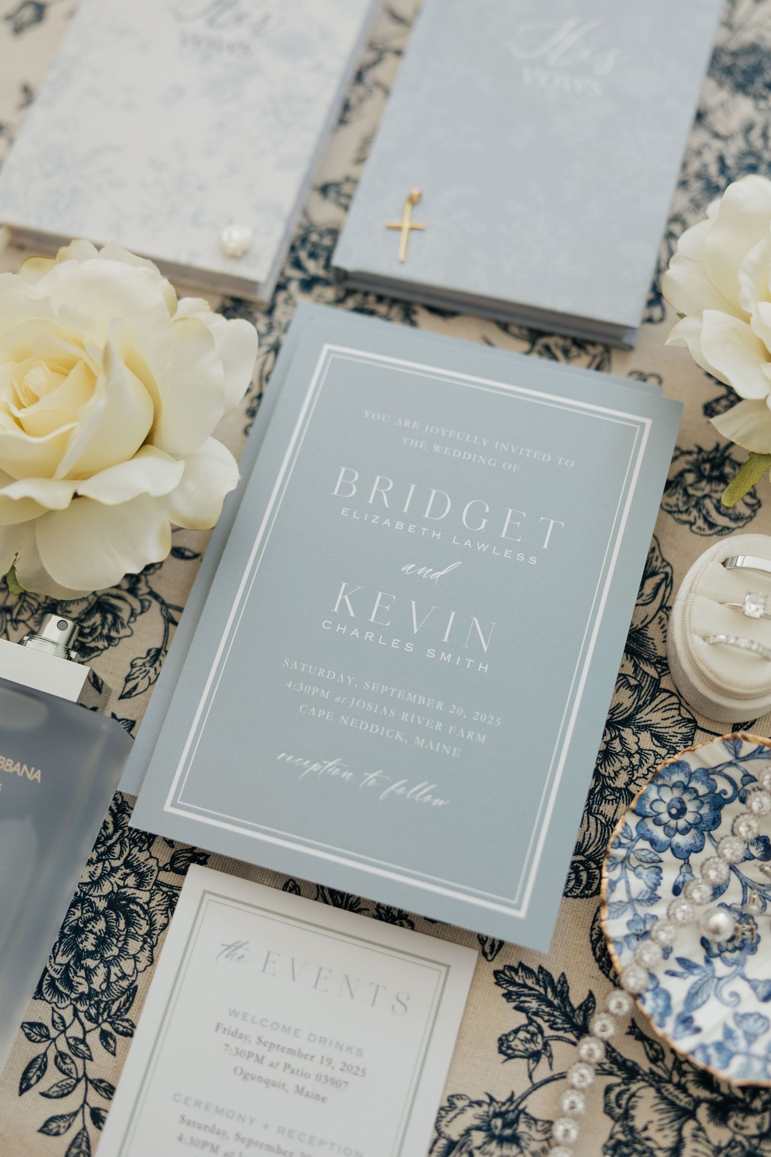 Elegant wedding invitation suite in soft gray with white roses and delicate floral pattern background.
