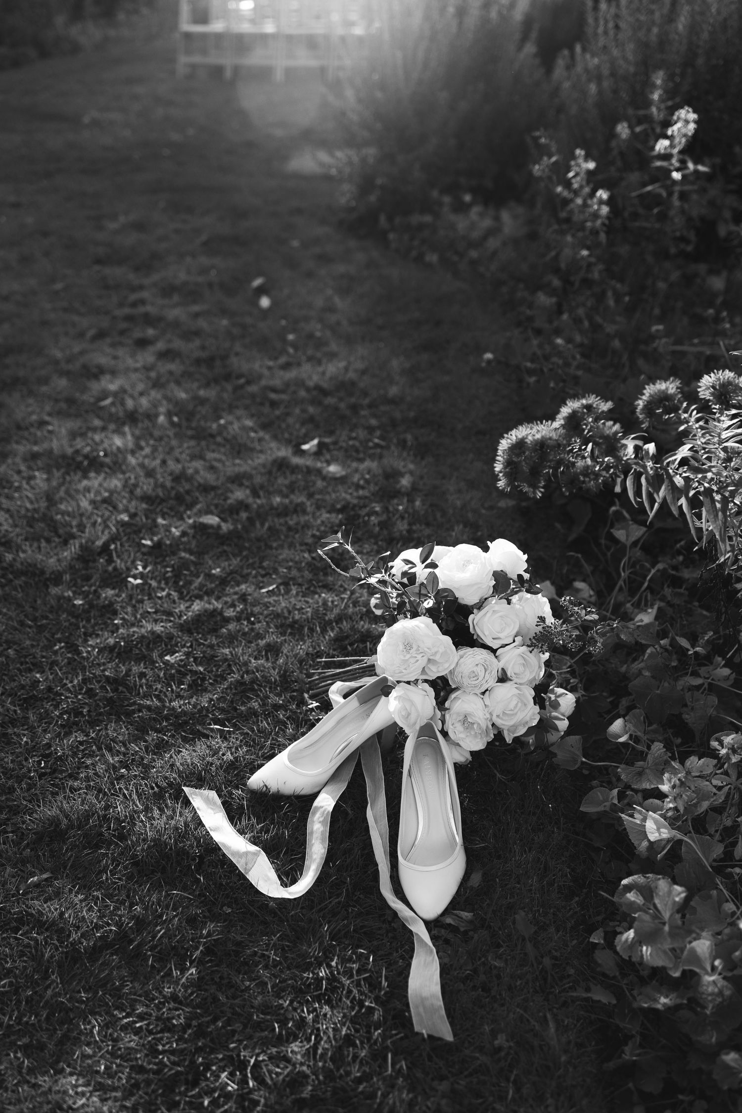 Black and white photos of flowers and ribbons arranged on grass.