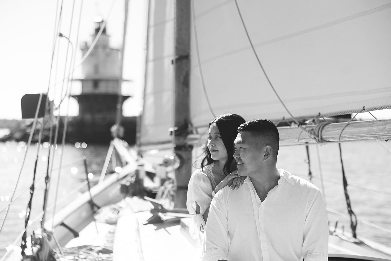 A couple enjoys a romantic moment together on a sailboat in black and white photography.