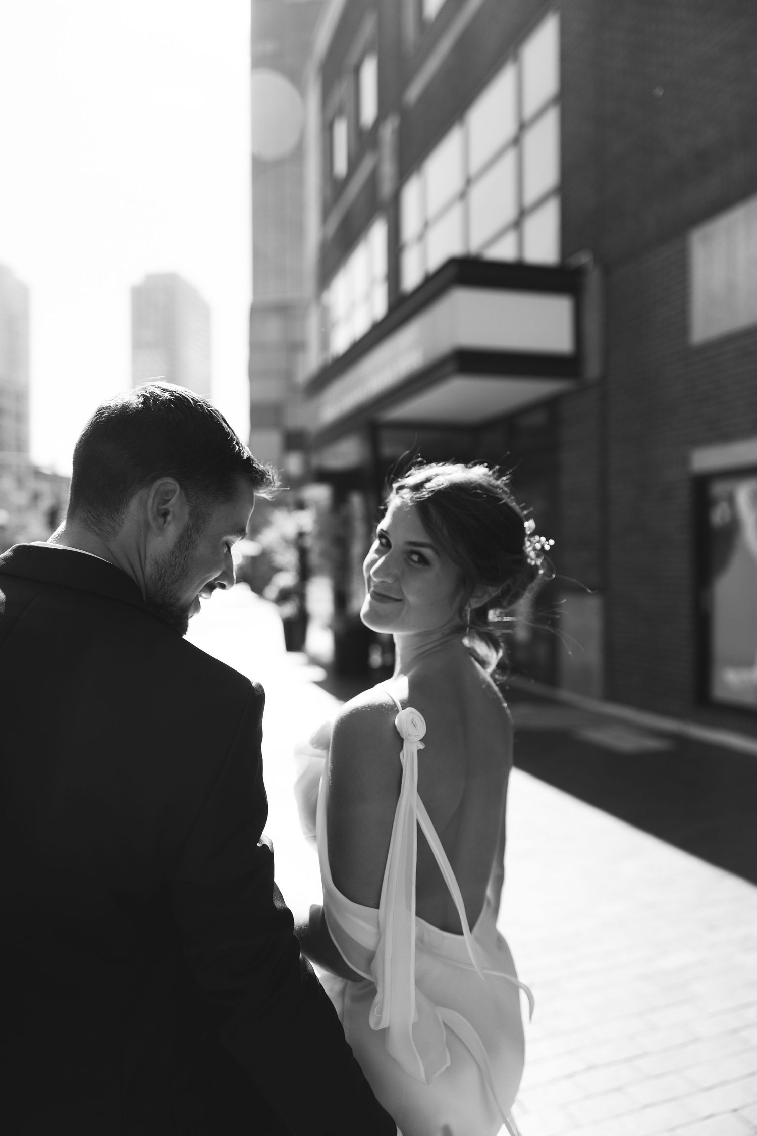 Black and white photo series showing a romantic couple embracing in dramatic urban lighting and shadows.