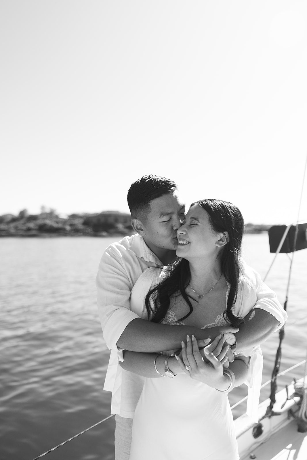 A romantic black and white photo sequence of a couple sharing tender moments while sailing on a boat.