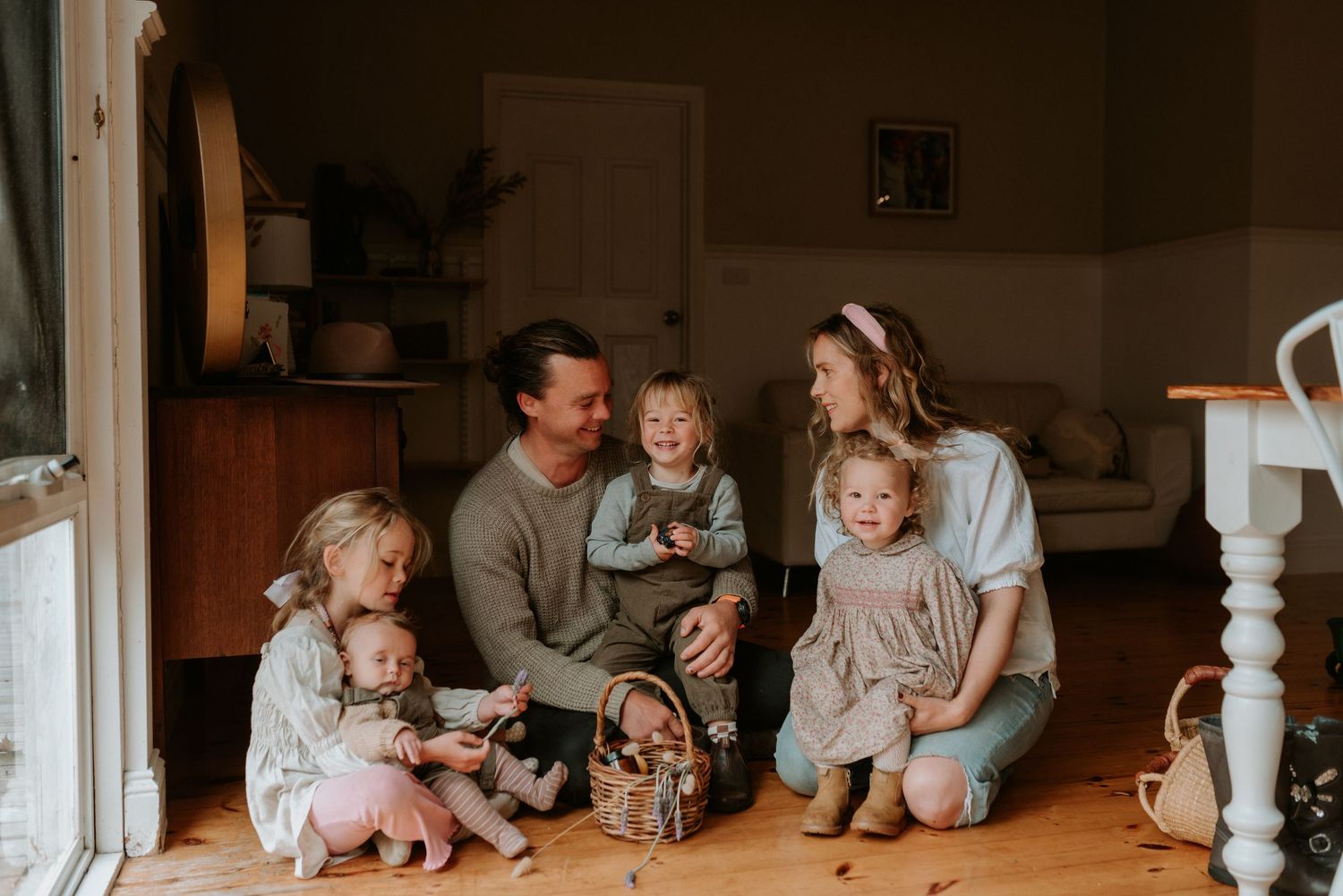 Family gathering in dimly lit living room for casual moments together.
