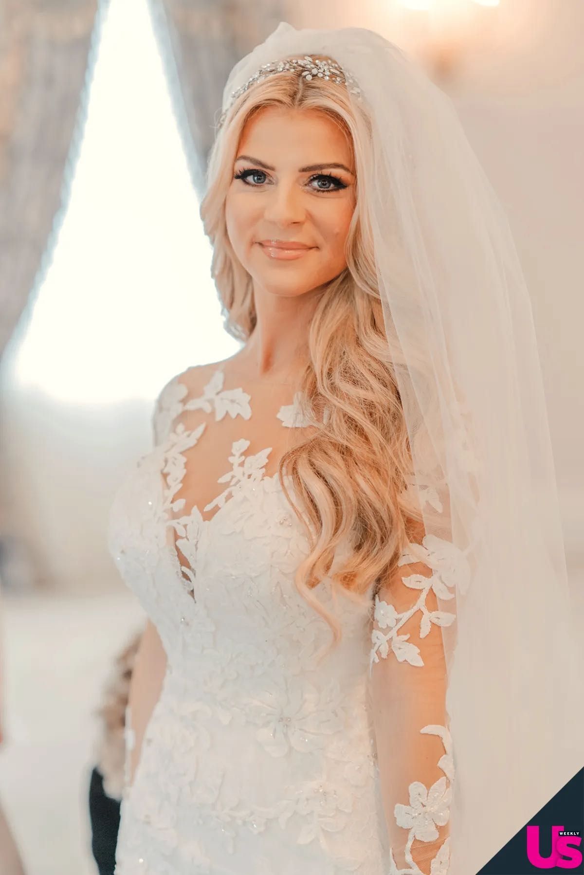 Beautiful blonde bride wearing lace long-sleeve wedding gown with veil and crystal tiara hair piece.
