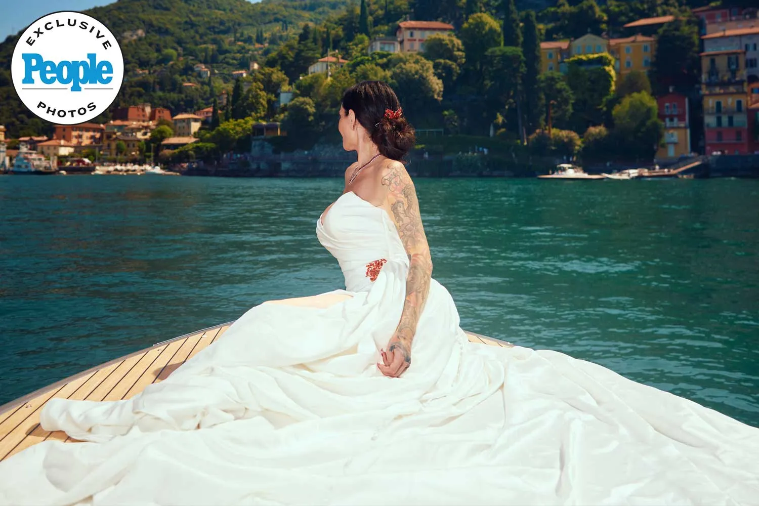 Bride in white gown sits gracefully on a boat at Lake Como, Italy, in an exclusive People magazine wedding photo.