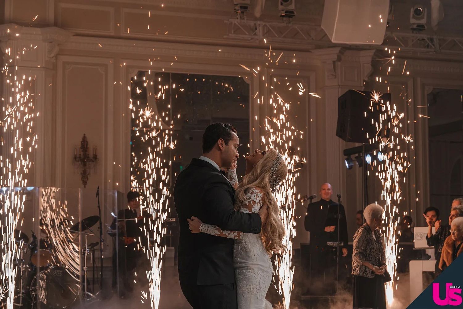 A couple shares their first dance surrounded by sparkling pyrotechnics at an elegant wedding reception venue.