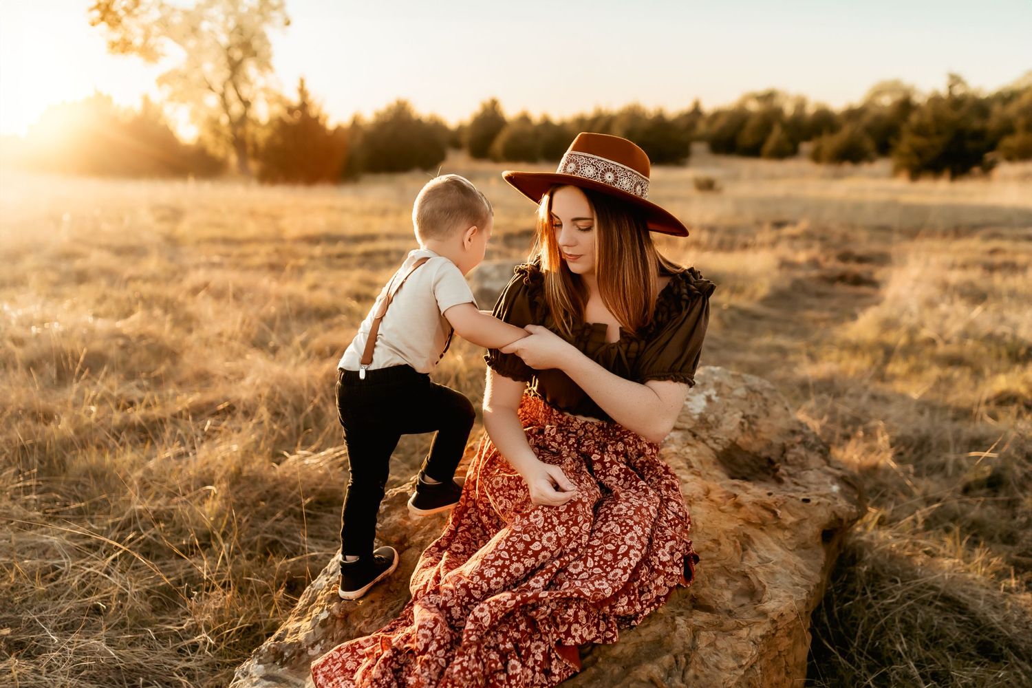 A tender moment between parent and child in a sunlit field at golden hour.
