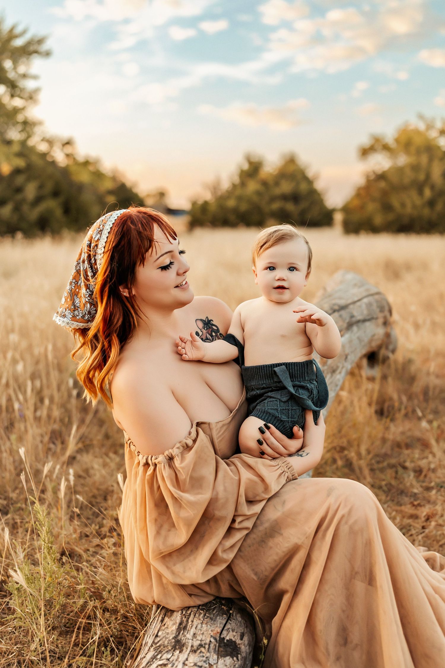 Tender outdoor portrait in golden field with flowing dress at sunset.