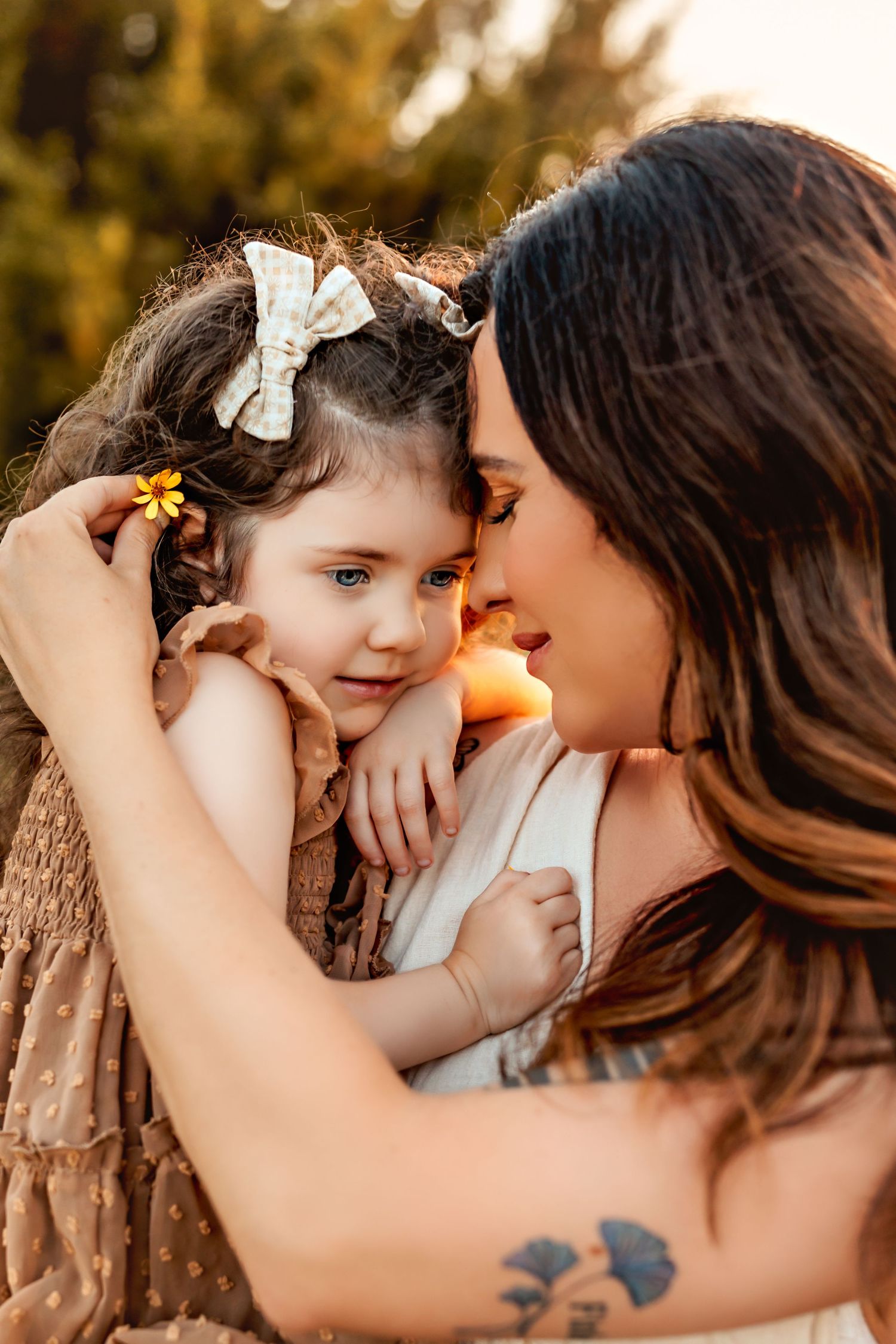Intimate portrait of parent and child sharing a tender moment at sunset.