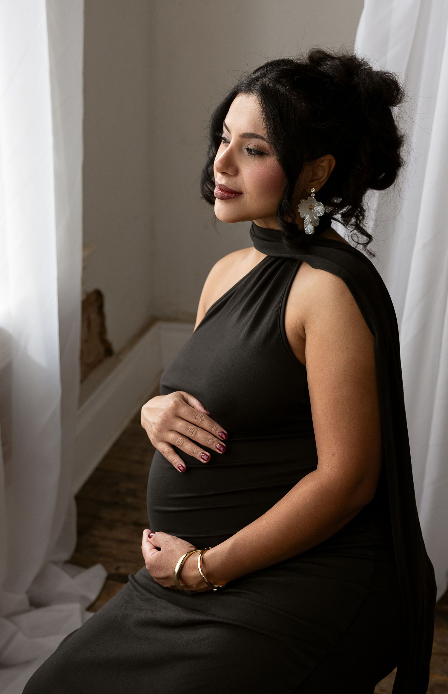 A series of intimate maternity portraits showing a pregnant woman in a black dress against soft window light.